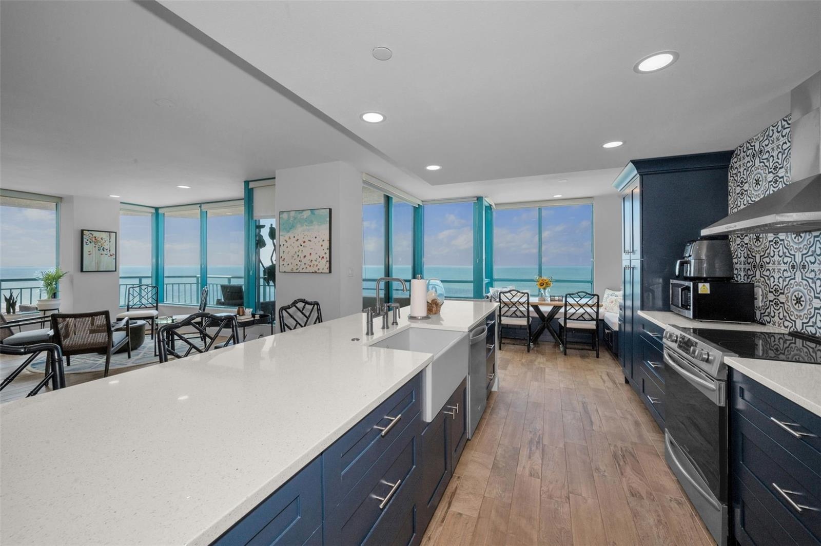Cucina Features Versay Grand Blue Encaustic Style Porcelain Tile Backsplash, Stainless appliances, Quartz Counter Surfaces, Custom Shaker Style Cabine