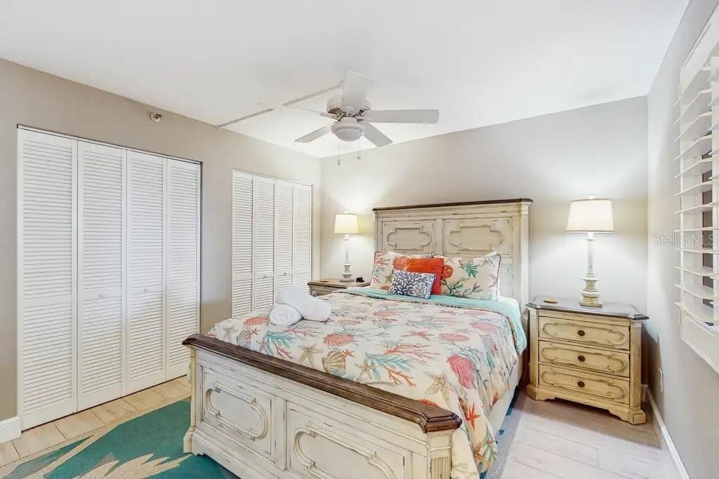 THIRD BEDROOM FEATURES DOUBLE CLOSETS, QUEEN SIZE BED, PLANTATION SHUTTERS, FLAT TV, AND CEILING FAN