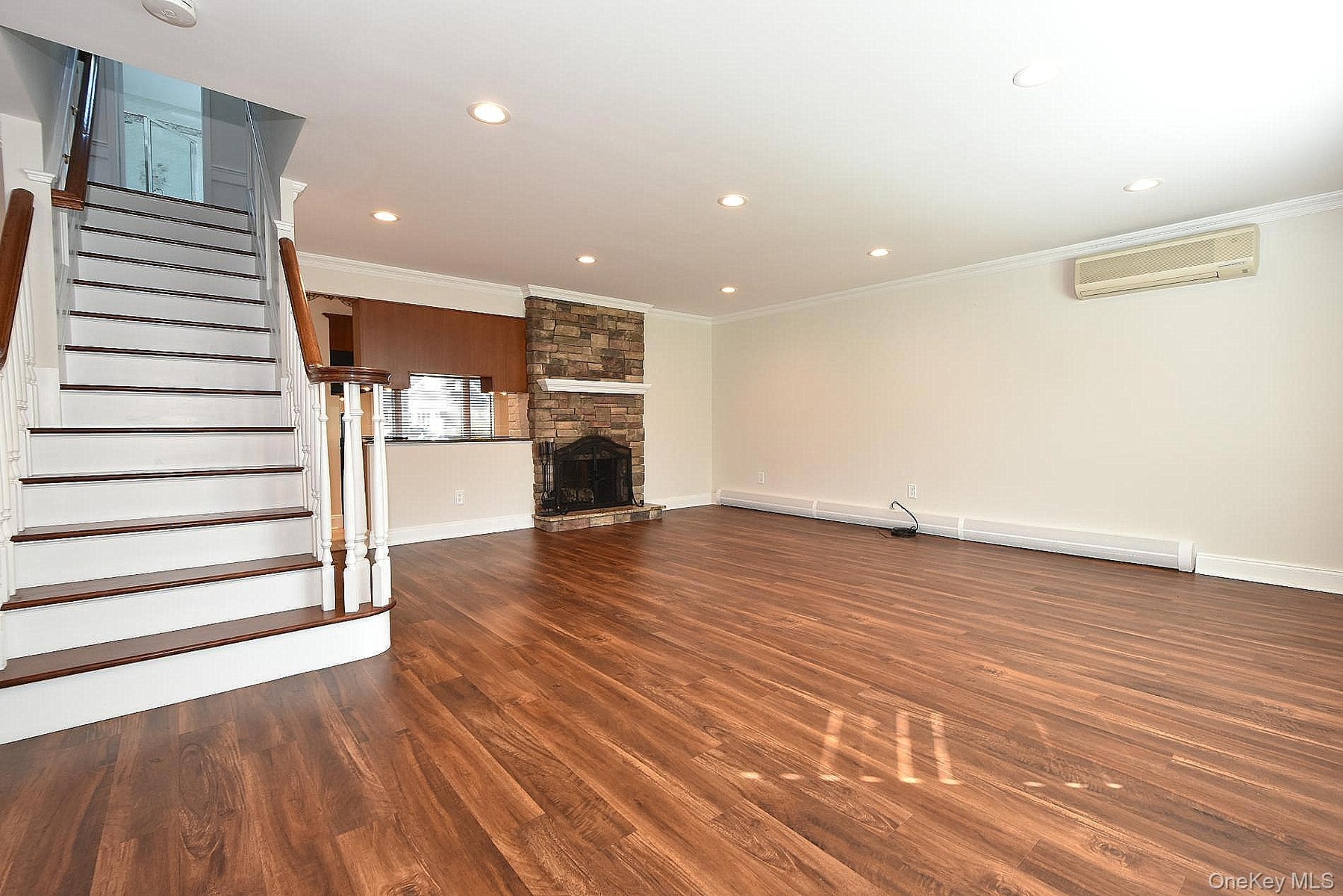 Den with engineered wood floors & recessed lights