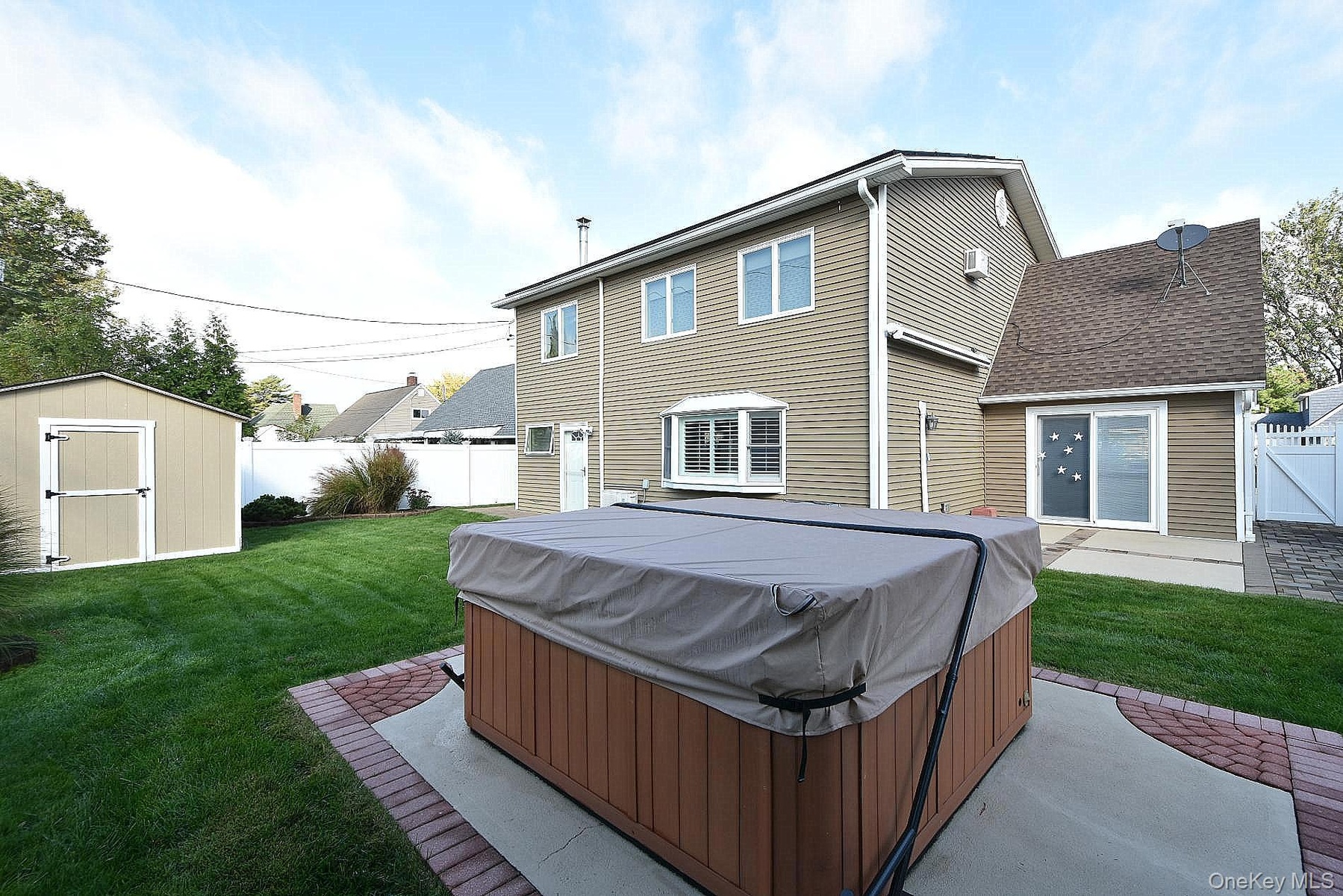 Backyard with hot tub and automated awning