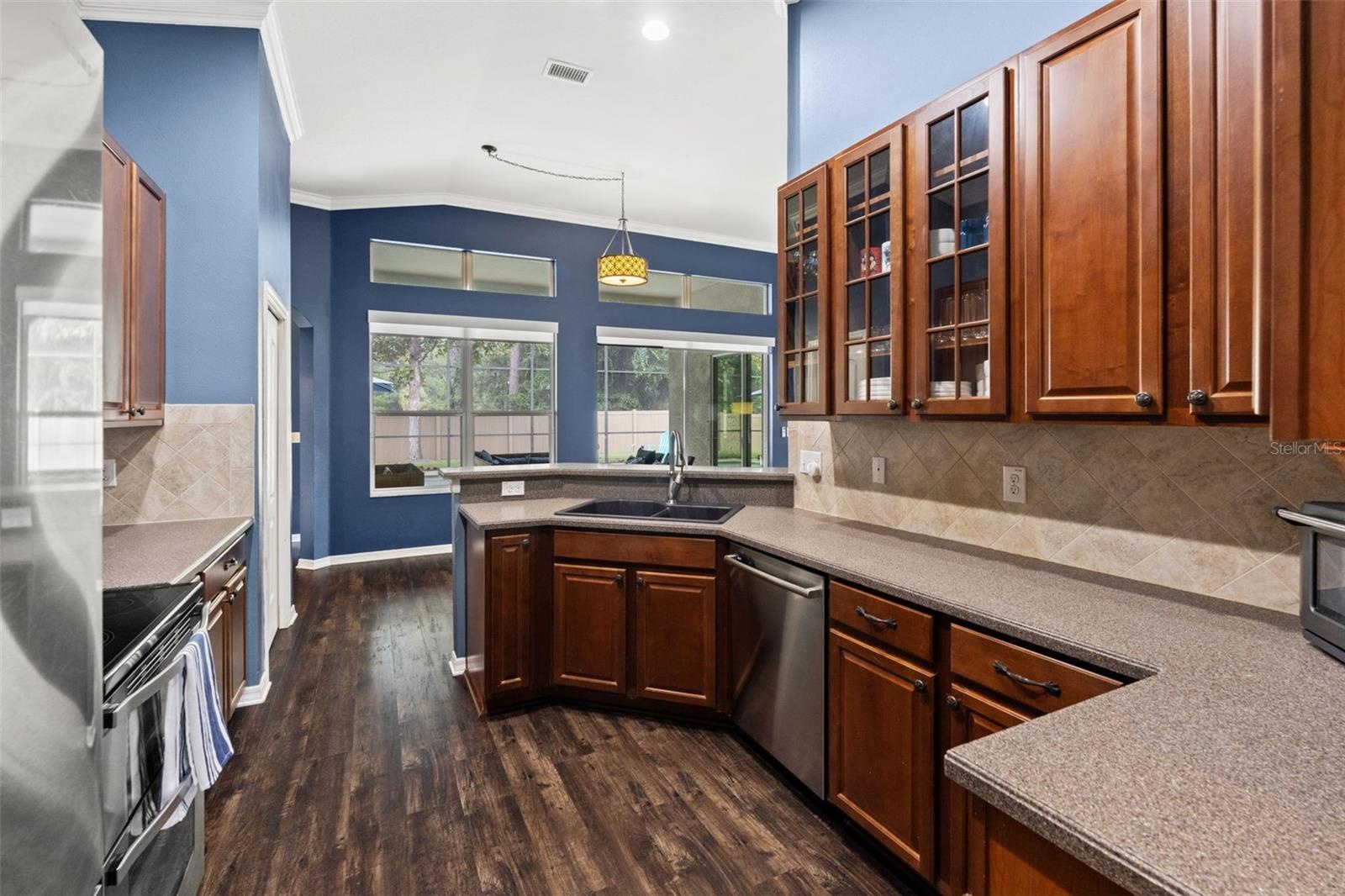 A large window over the sink brings natural light into the kitchen and provides a view toward the outdoor living area.