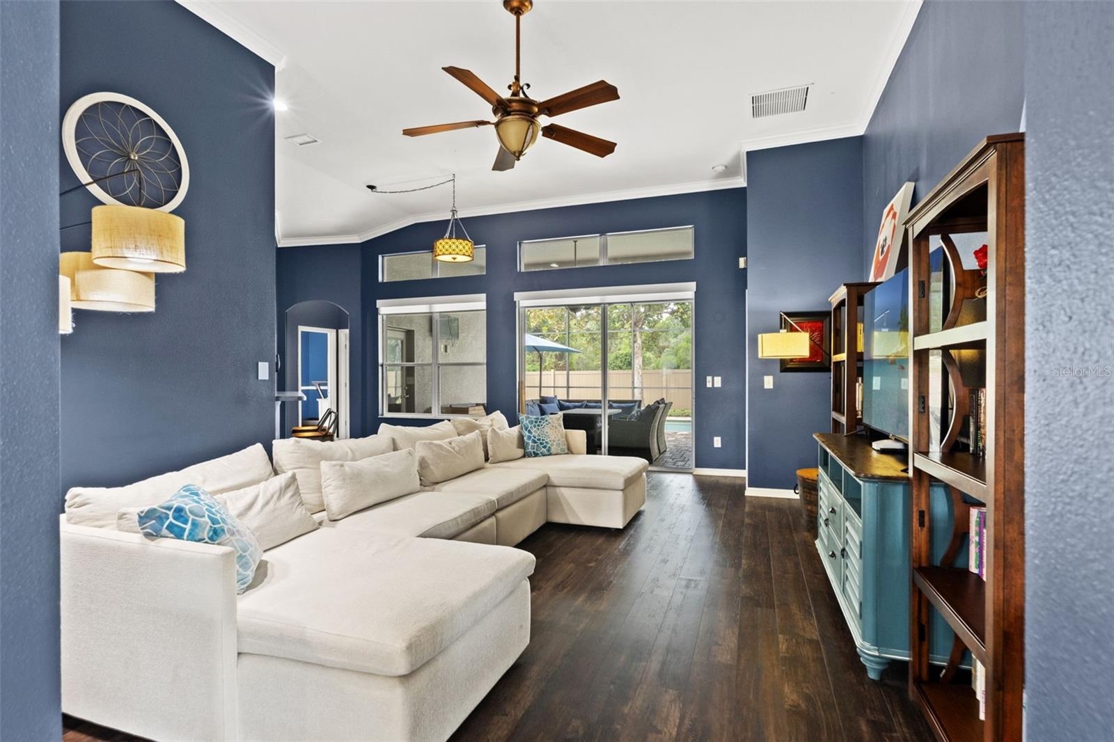 Natural light pours into the family room, with views toward the screened pool and outdoor living area.