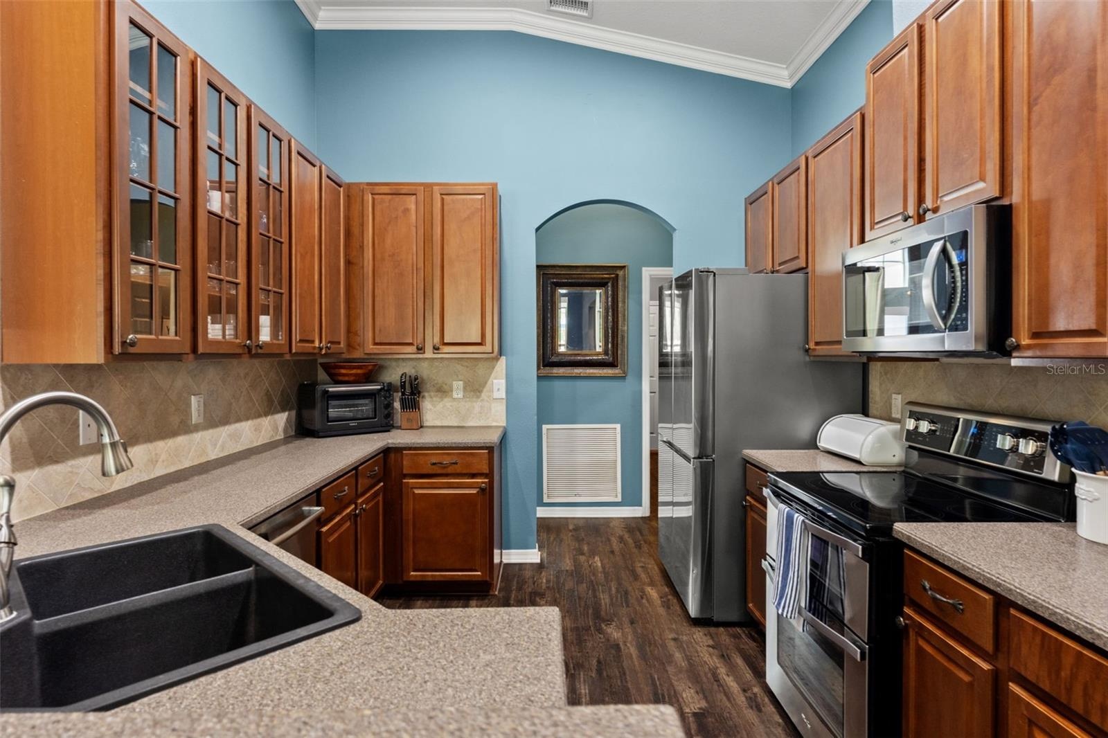 The kitchen offers abundant wood cabinetry, generous counter space, stainless appliances, and plenty of room for everyday meal prep.