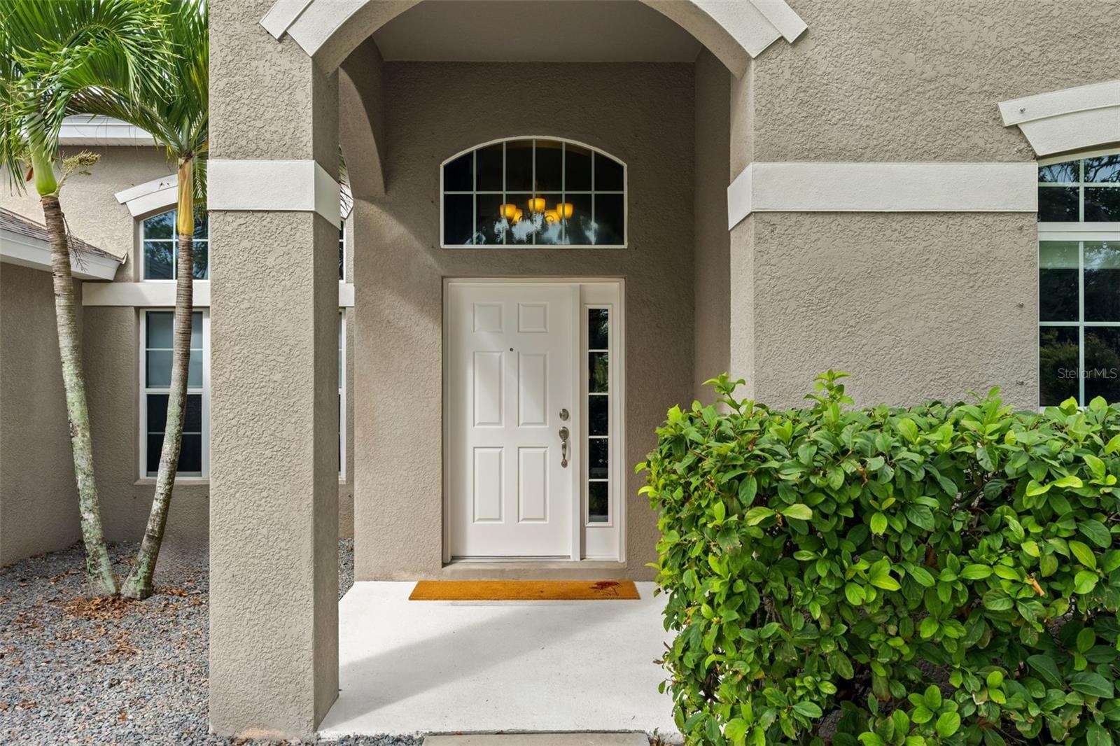 The covered front entry creates a welcoming arrival, with an arched transom bringing additional natural light inside.