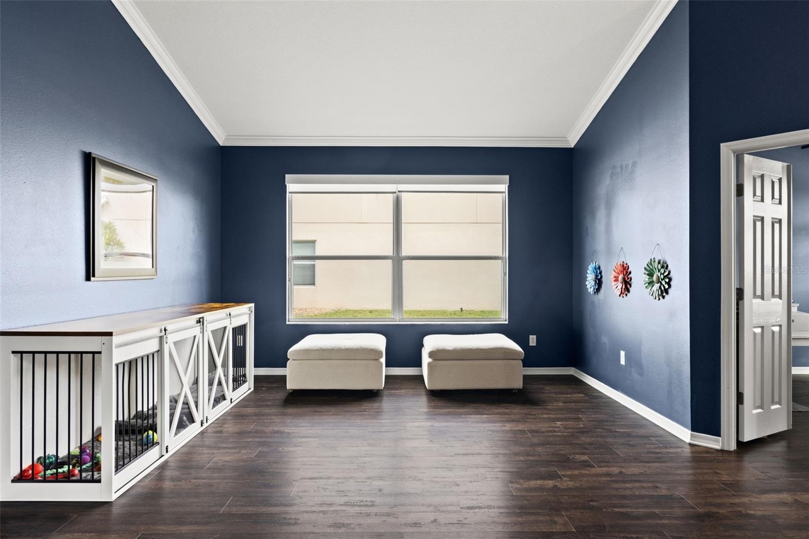 Large front windows fill this versatile living space with natural light while the open layout keeps the home feeling connected.
