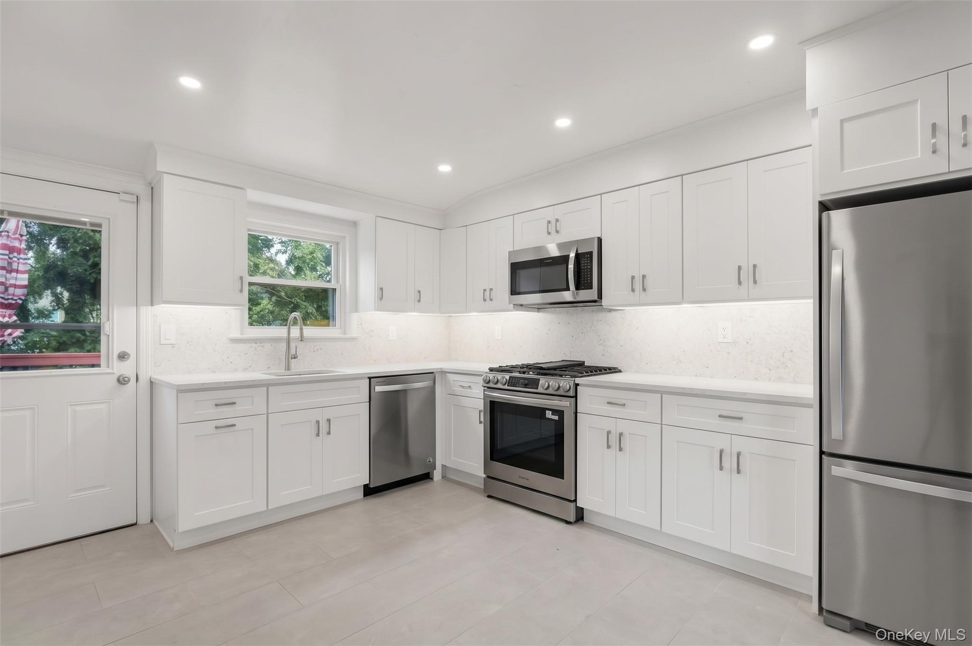 Clean, timeless design with thoughtful details, including quartz countertops, soft-close cabinetry, stainless steel appliances, and a striking mosaic 