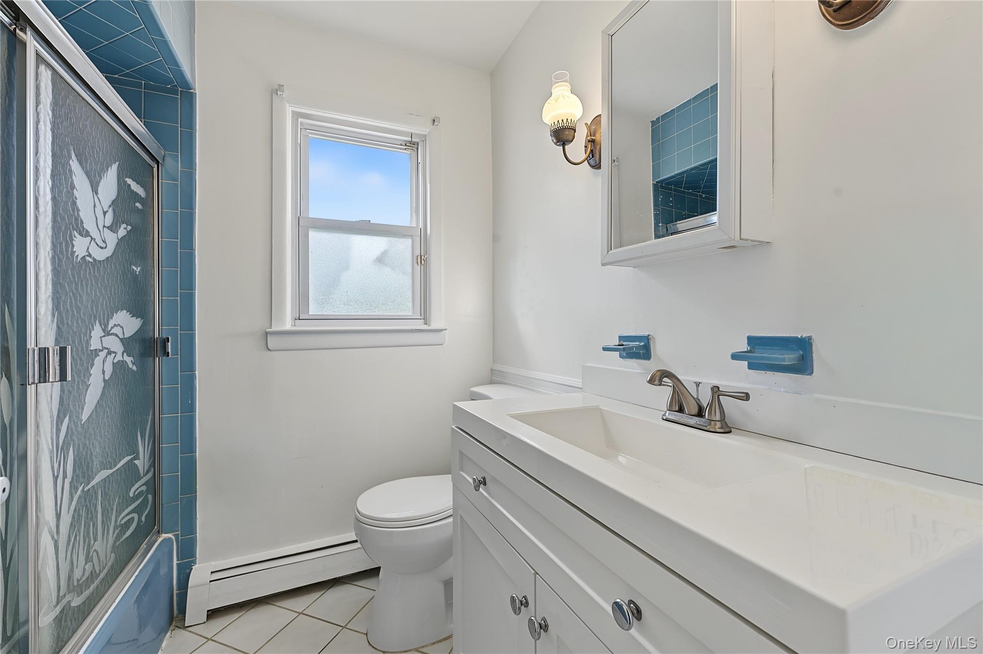 First floor bathroom with updated Vanity with integrated sink, white cabinetry and tub/shower ombo