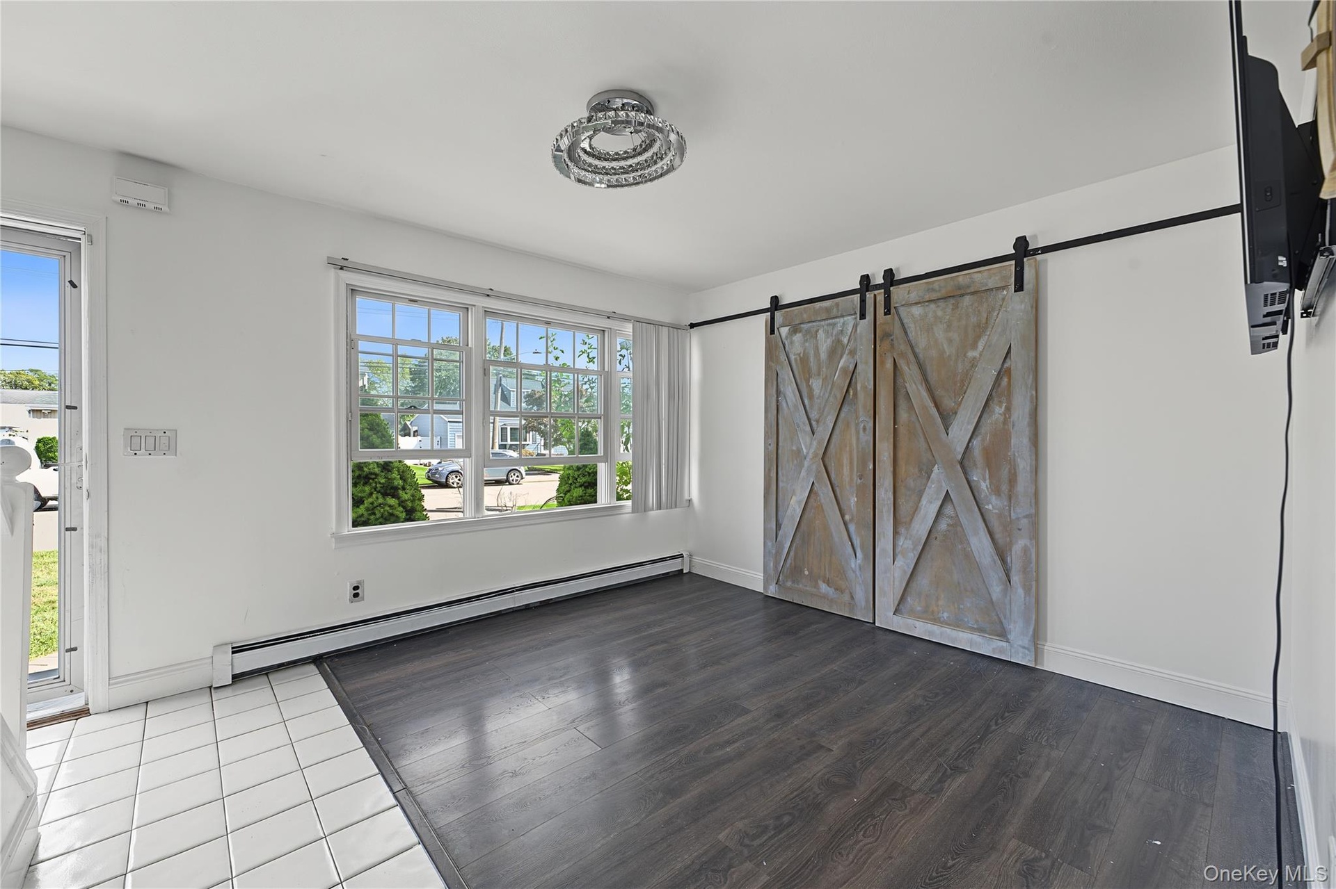 vinyl flooring with white baseboards view from the kitchen featuring the same barn doors