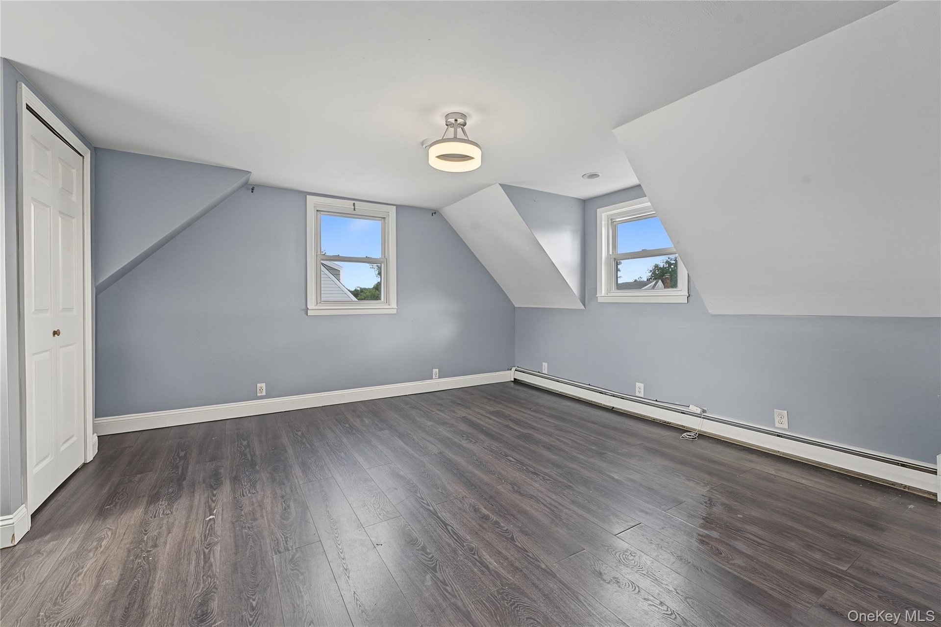 Third bedroom located on the second floor features a Sloped ceilings, two sash windows, bi-fold closet, and ceiling-mounted lighting fixture