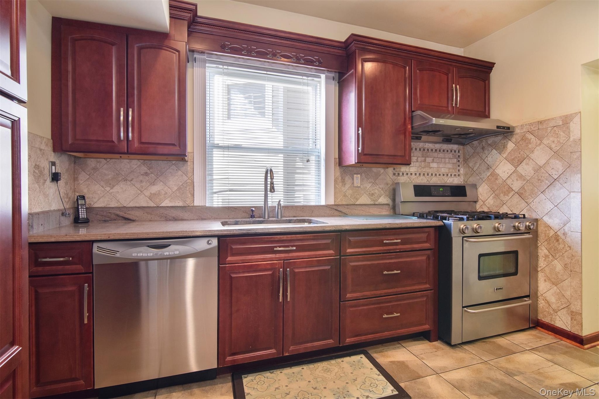 Kitchen featuring stainless steel appliances, exquisite Cherry cabinets, and tiled floor