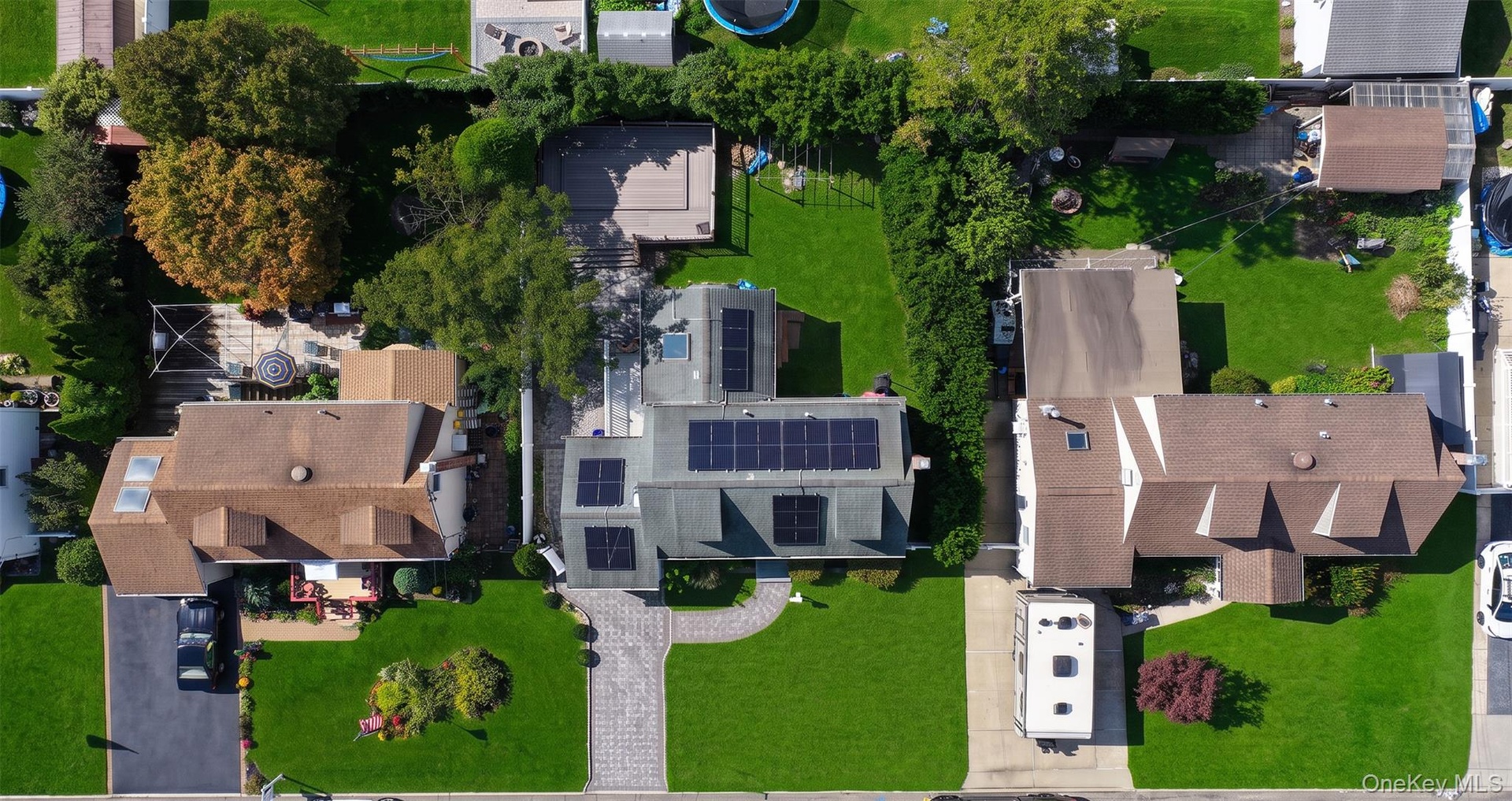 Gated property with  expansive paved driveway and mature trees