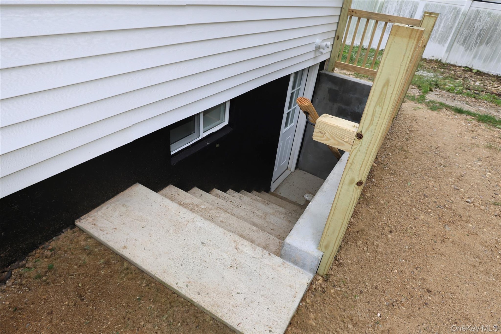 Concrete exterior stairs leading to a white door