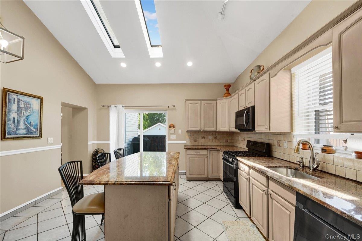 Open updated kitchen with skylights and access to side deck