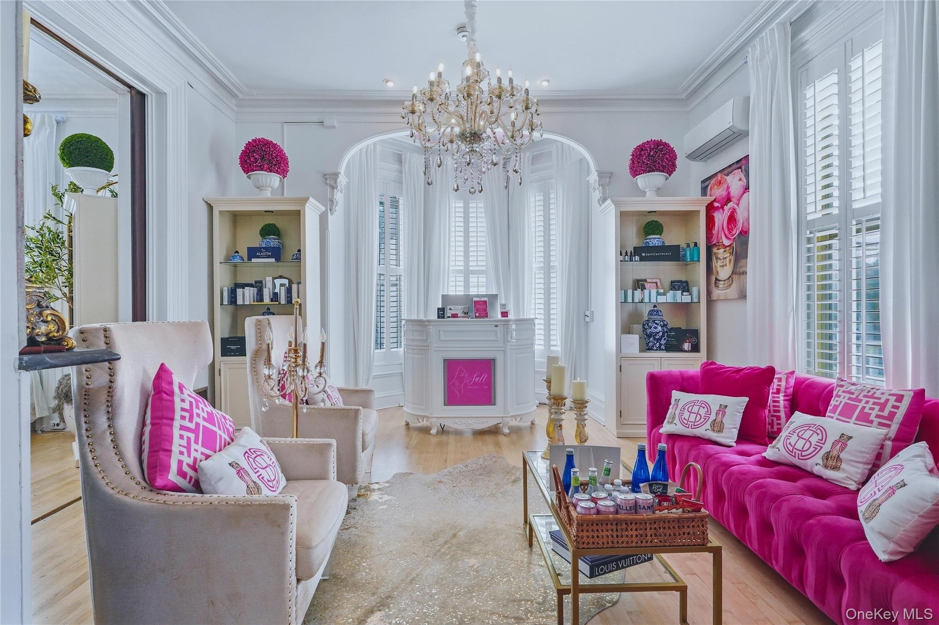 Hardwood flooring, crown molding, built-in display cabinetry, crystal chandelier, and interior shuttered windows