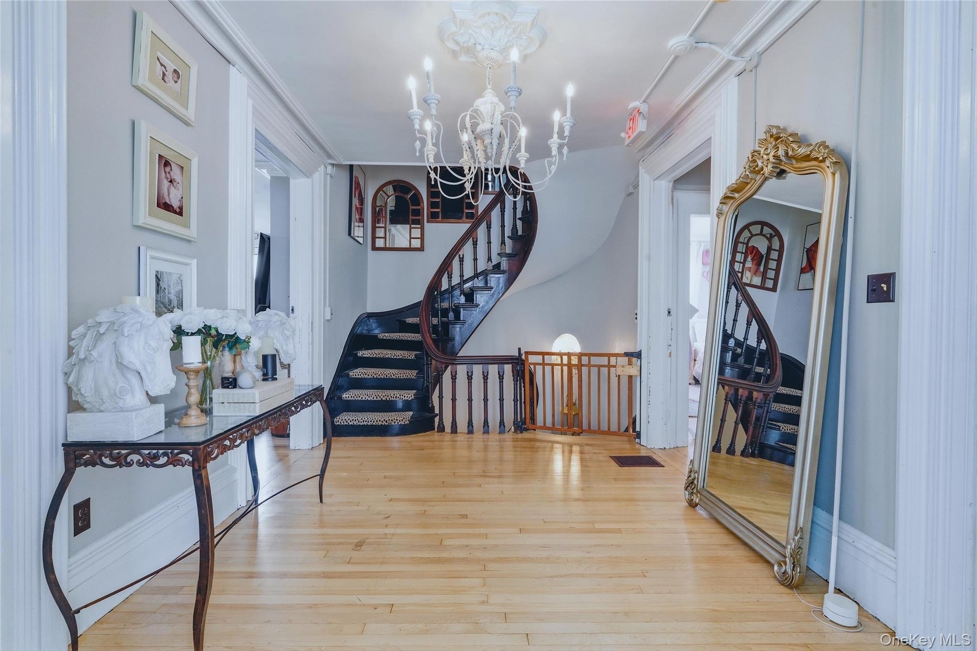 Wood-finish flooring, a curved staircase with dark wood treads, and white balusters