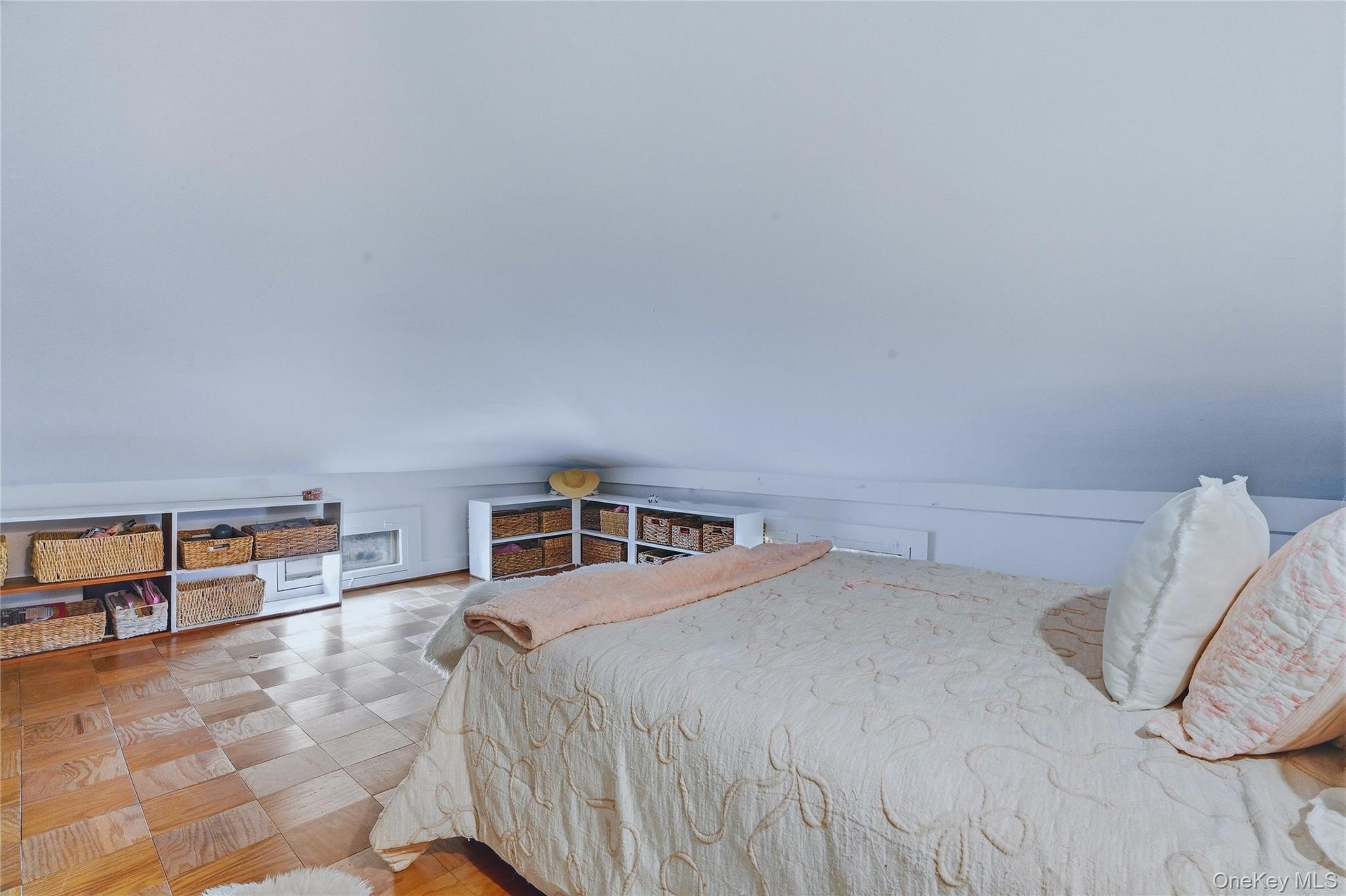 Sloped ceiling, wood-finish flooring, and built-in shelving