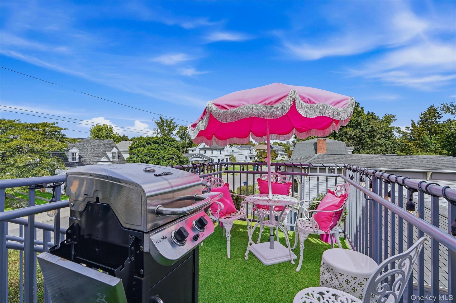 Rooftop balcony featuring metal railings and an artificial turf surface