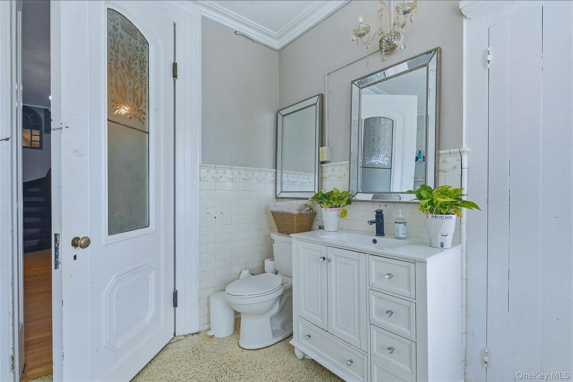 White vanity with integrated sink, black single-handle faucet, and mirrored storage cabinet