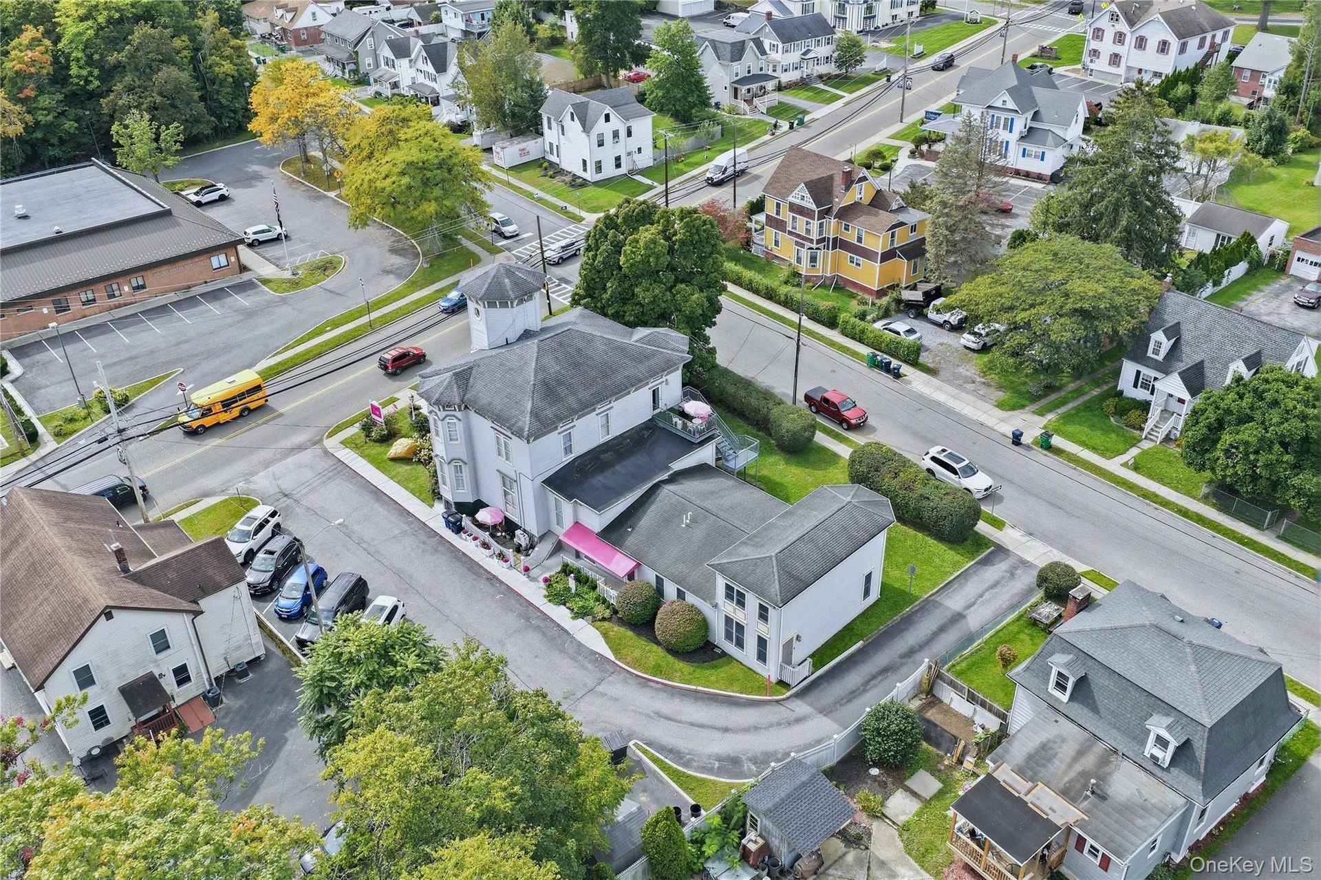 Multi-level building with a turret, multiple street-facing entrances, and a paved parking area