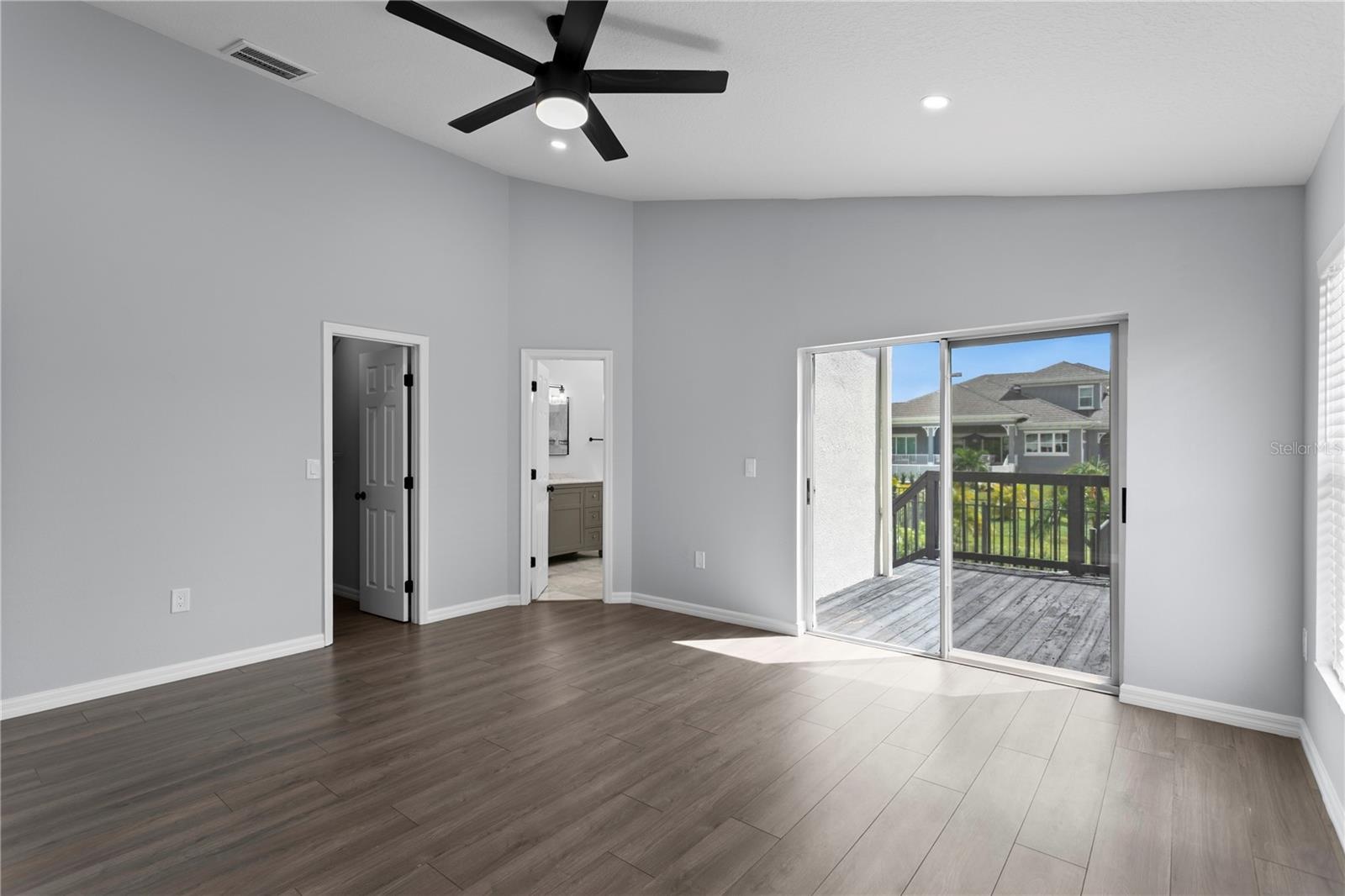 The primary bedroom features sliding doors that lead to the private deck.