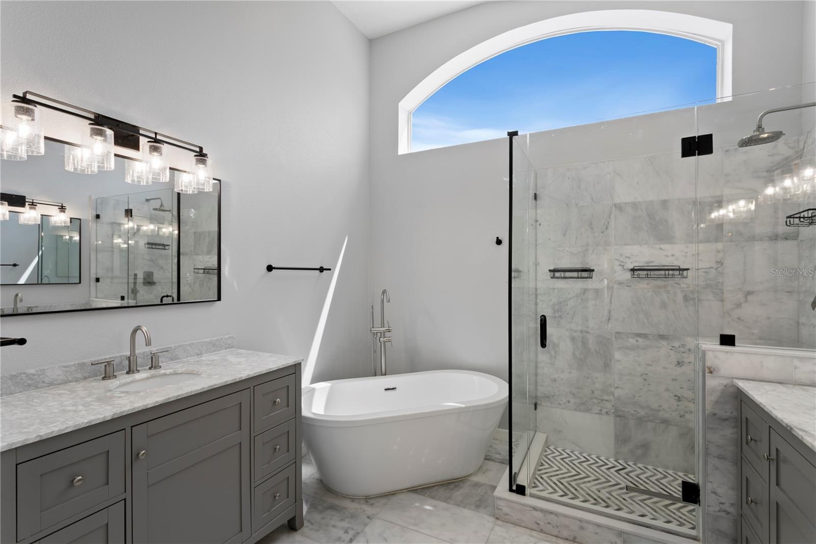 The elegant primary bath features dual vanities, a luxurious soaking tub and oversized walk-in shower.