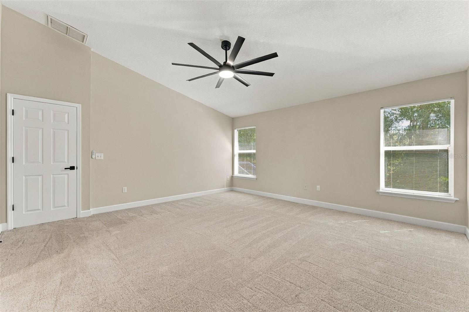Primary bedroom with brand new carpet and ceiling fan