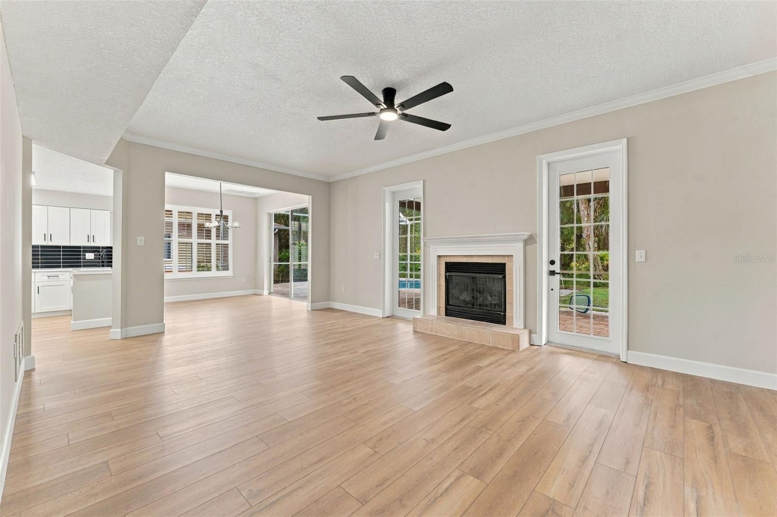 Inviting family room with fireplace and French doors leading to the back porch and pool deck