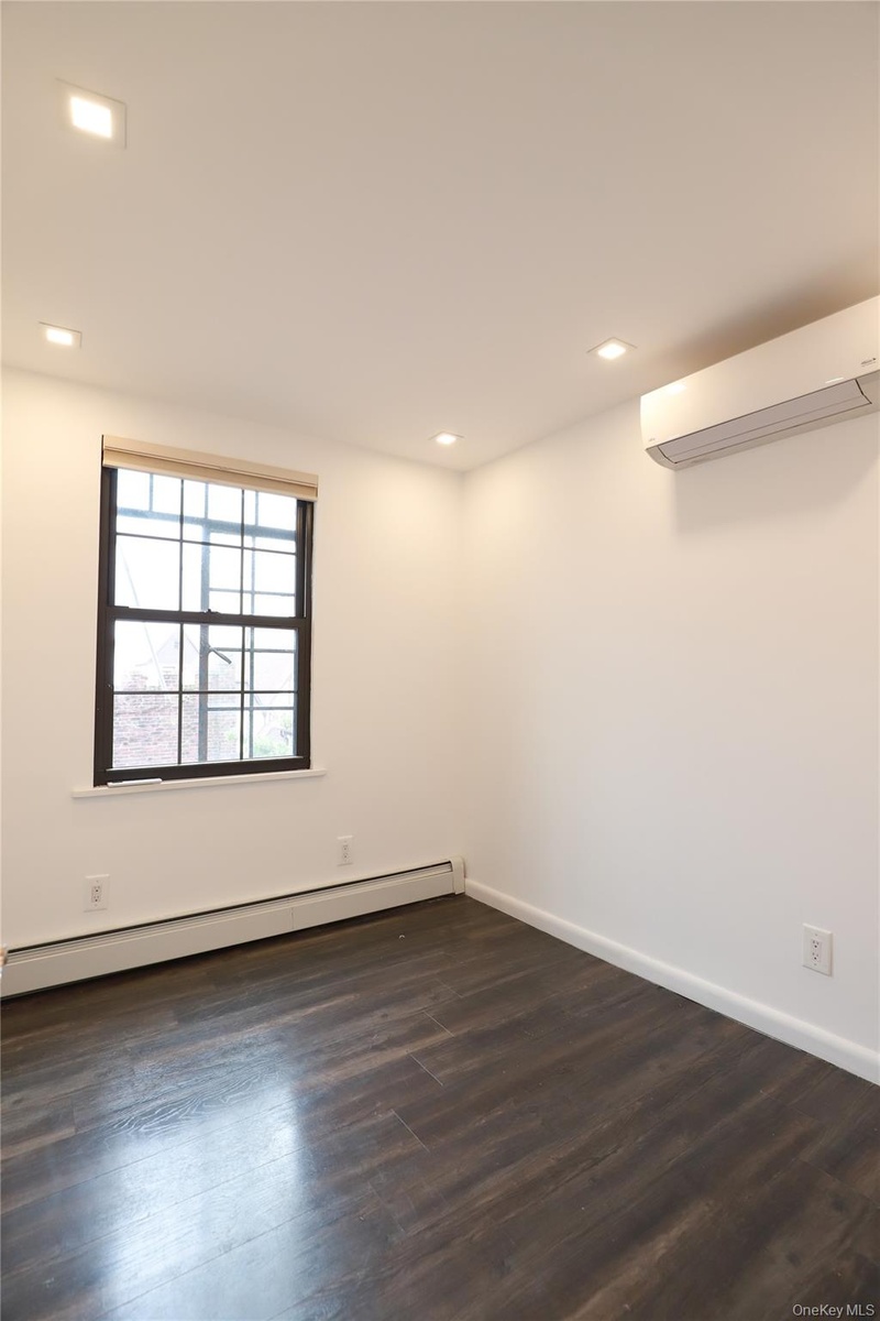 Recessed lighting, wood-finish flooring, and white walls create a bright interior