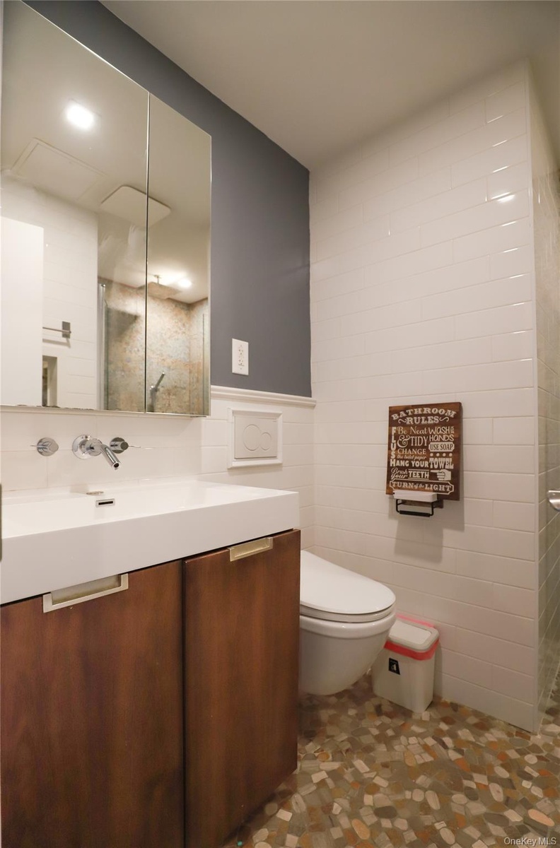 Bathroom with vanity, tile walls, heated spa-like flooring, and a standing shower