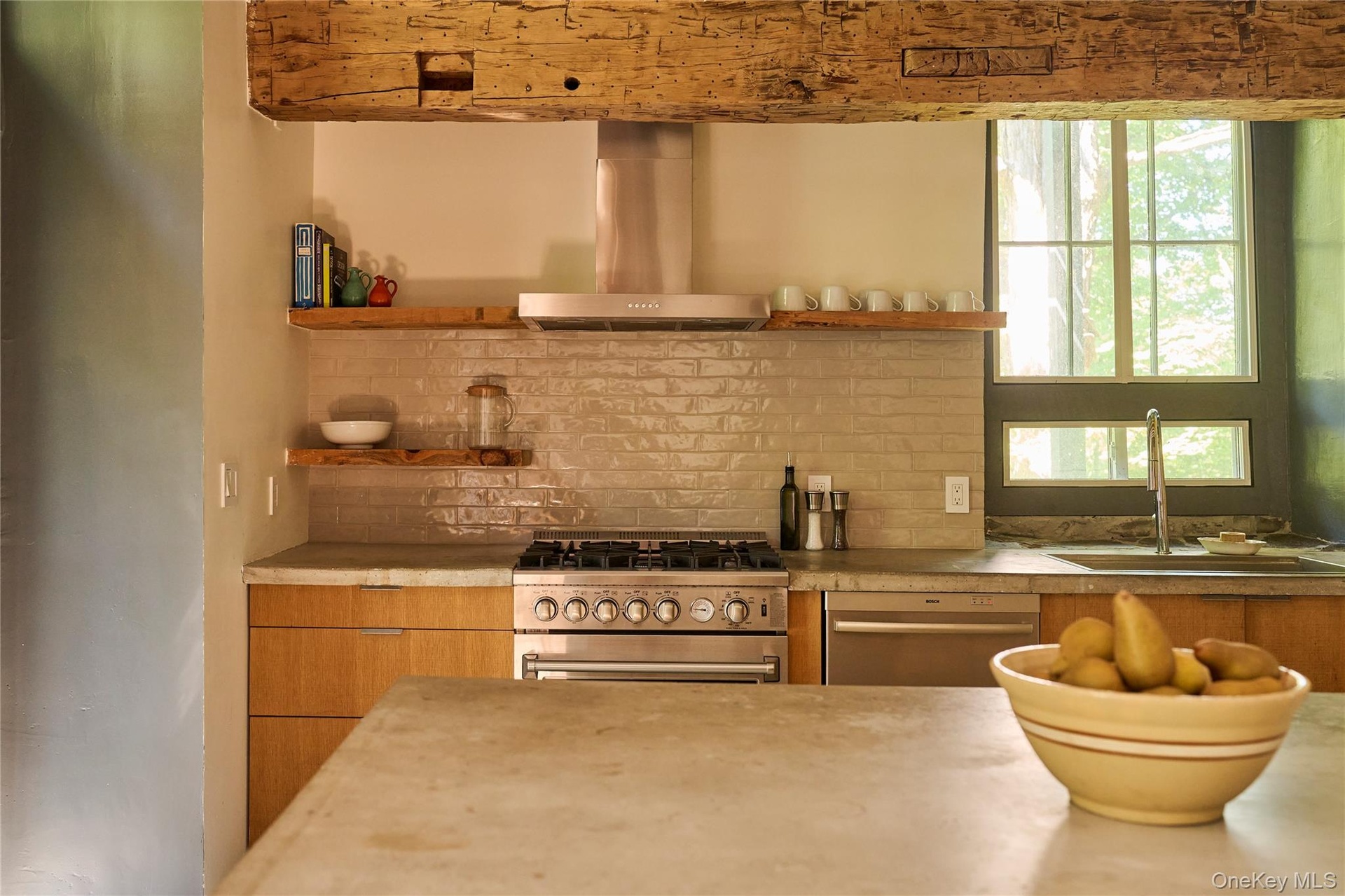 Kitchen featuring range hood, open shelves, stainless steel appliances, light countertops, and modern cabinets