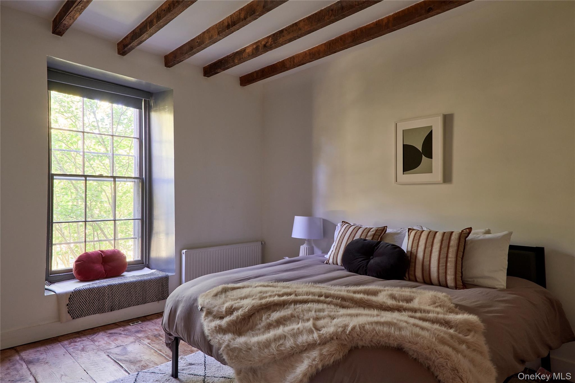 Bedroom featuring radiator heating unit and beamed ceiling