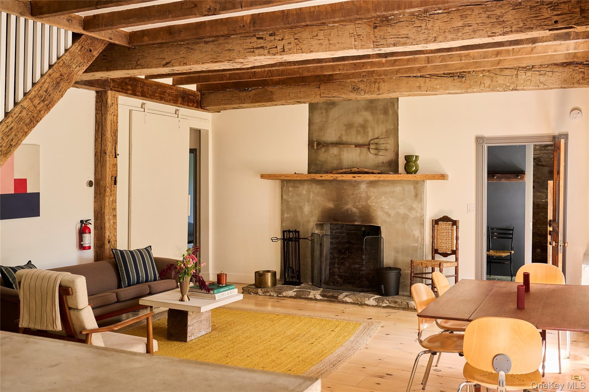 Living room with a premium fireplace, beamed ceiling, and hardwood / wood-style floors
