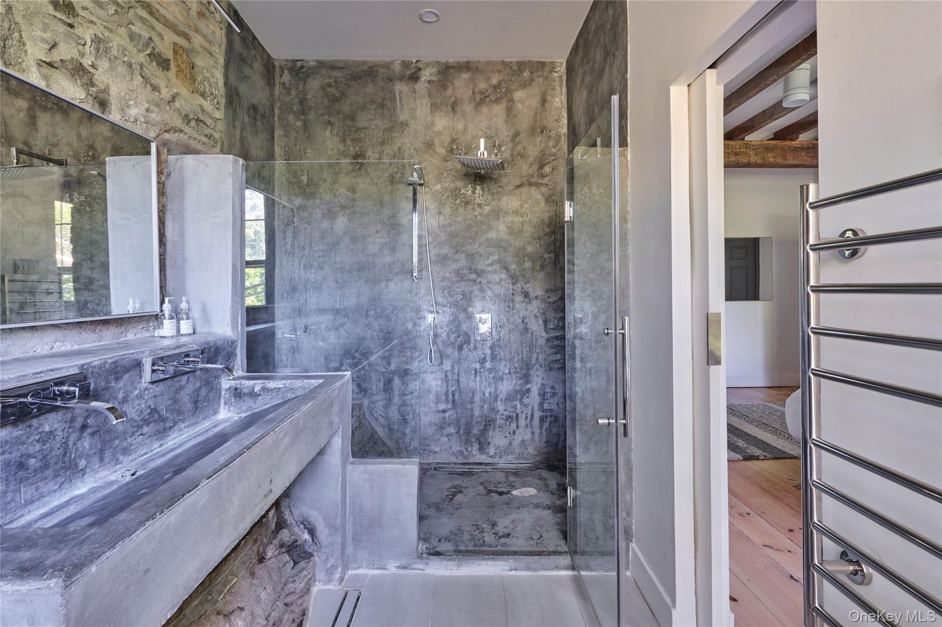 Bathroom featuring a marble finish shower and vanity