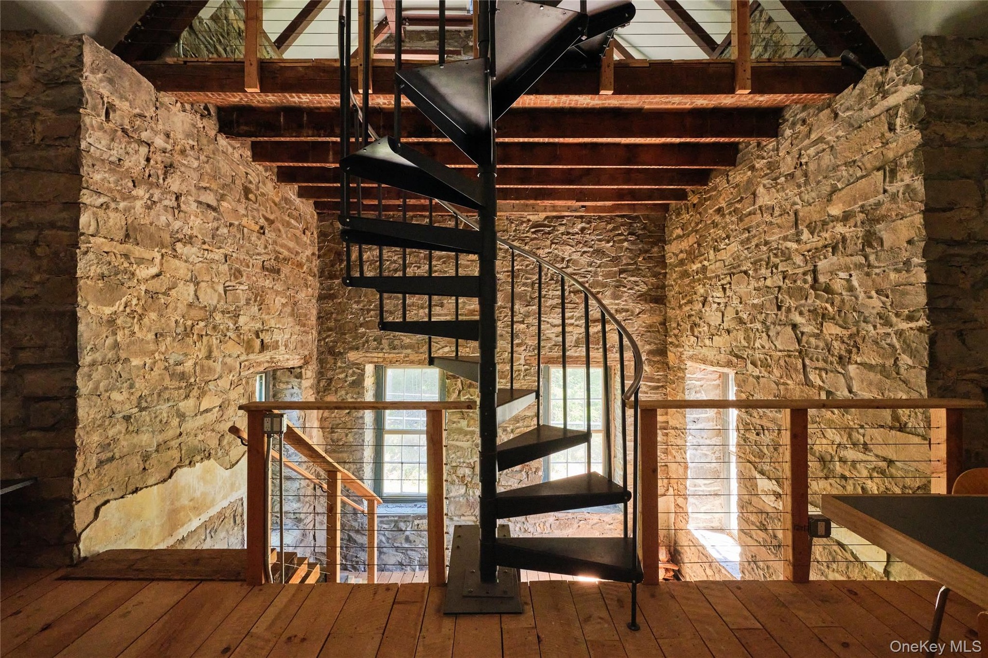 Staircase featuring beamed ceiling, a towering ceiling, and wood-type flooring