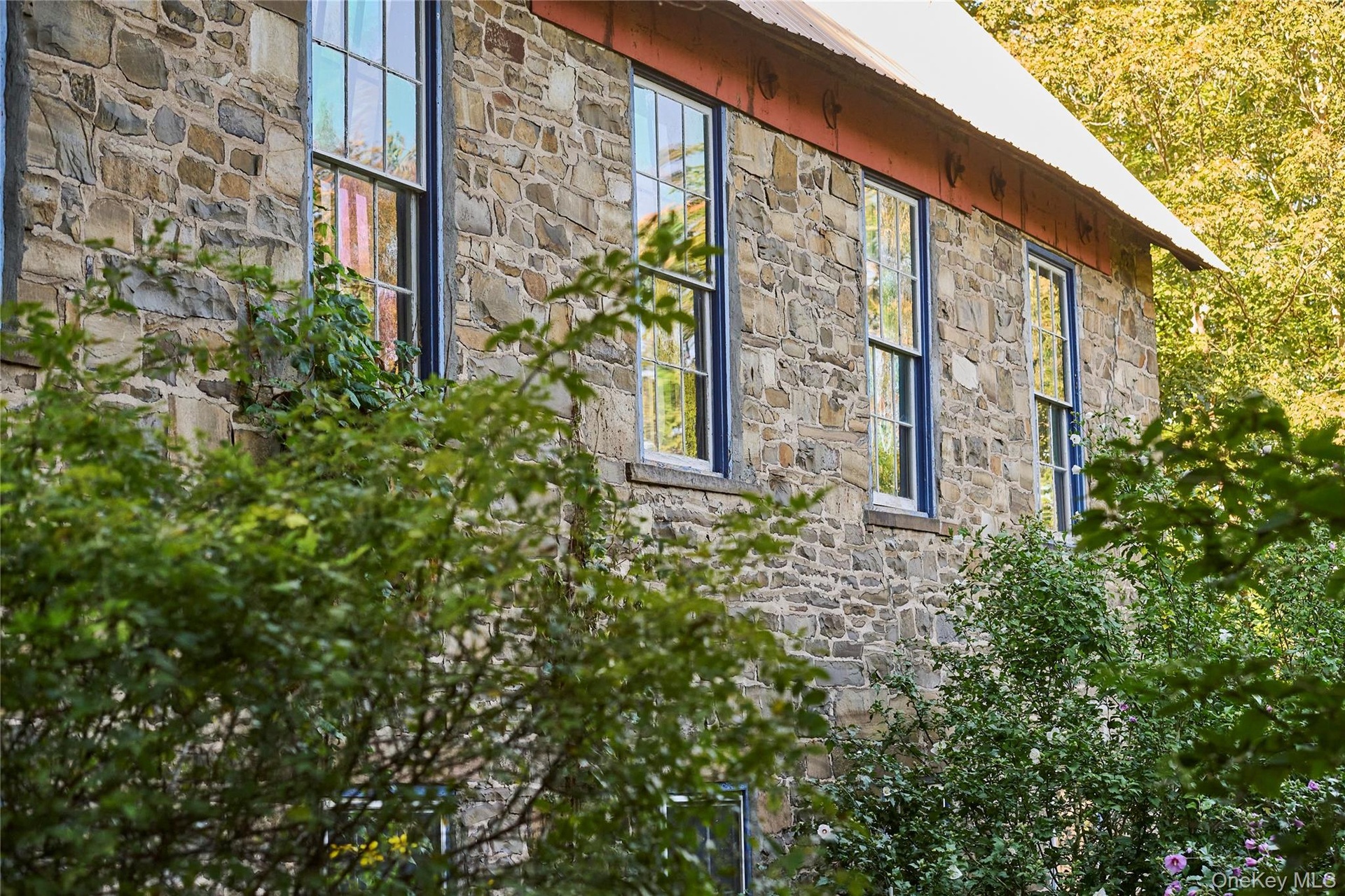 View of home's exterior with stone siding and a metal roof