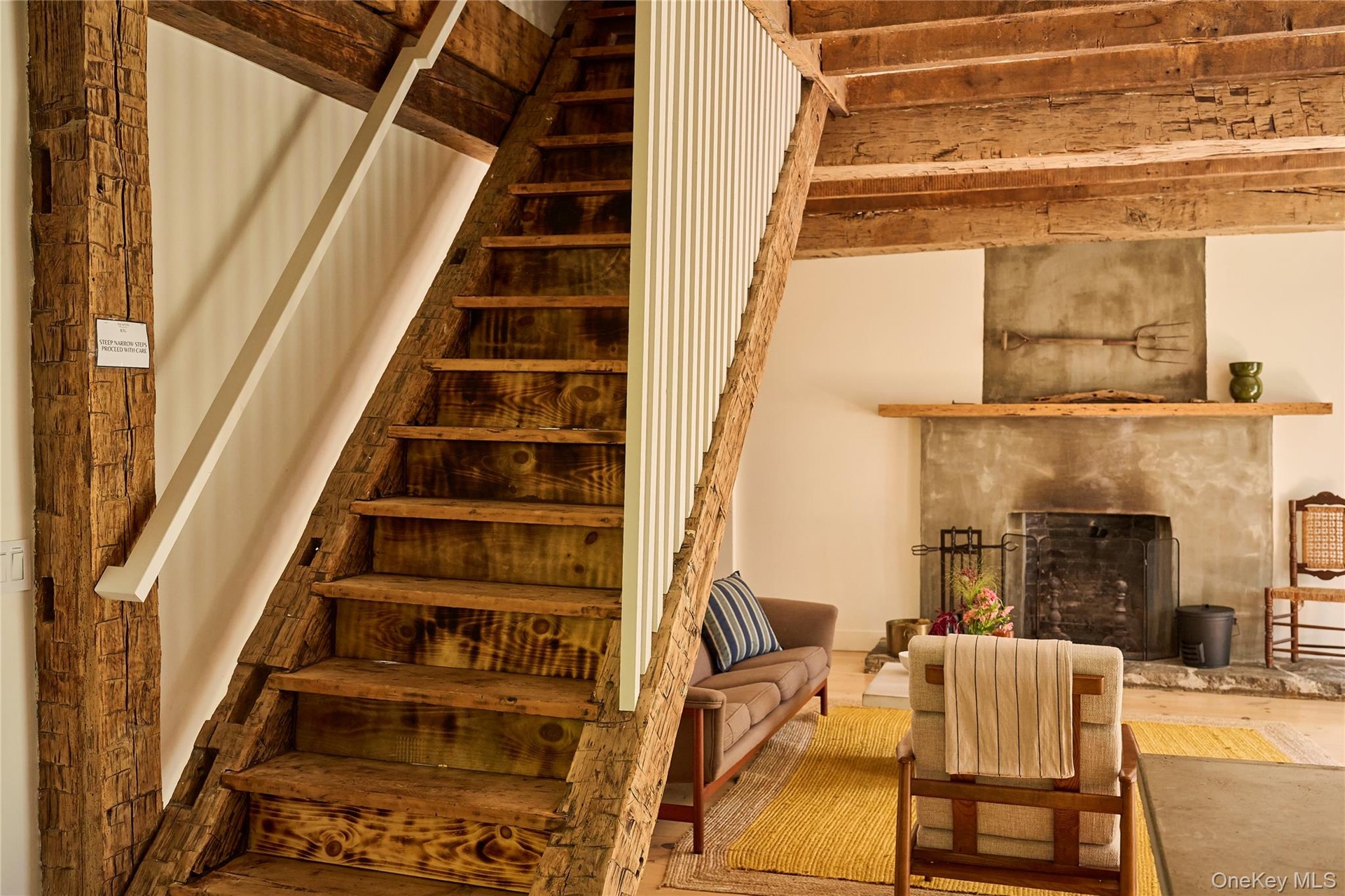 Staircase with a high end fireplace and wood finished floors