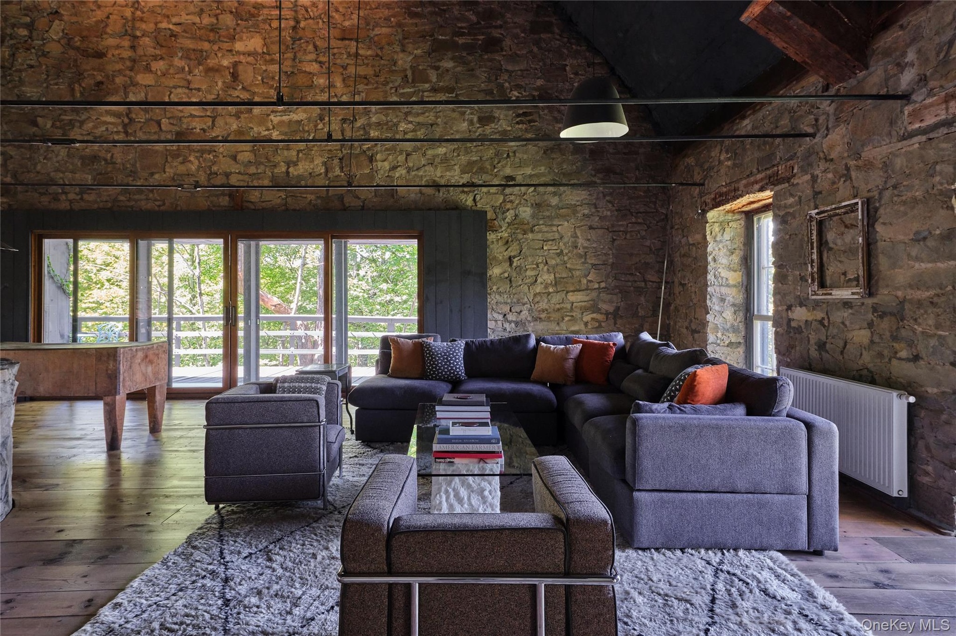 Living room featuring hardwood / wood-style flooring, radiator, high vaulted ceiling, and beamed ceiling