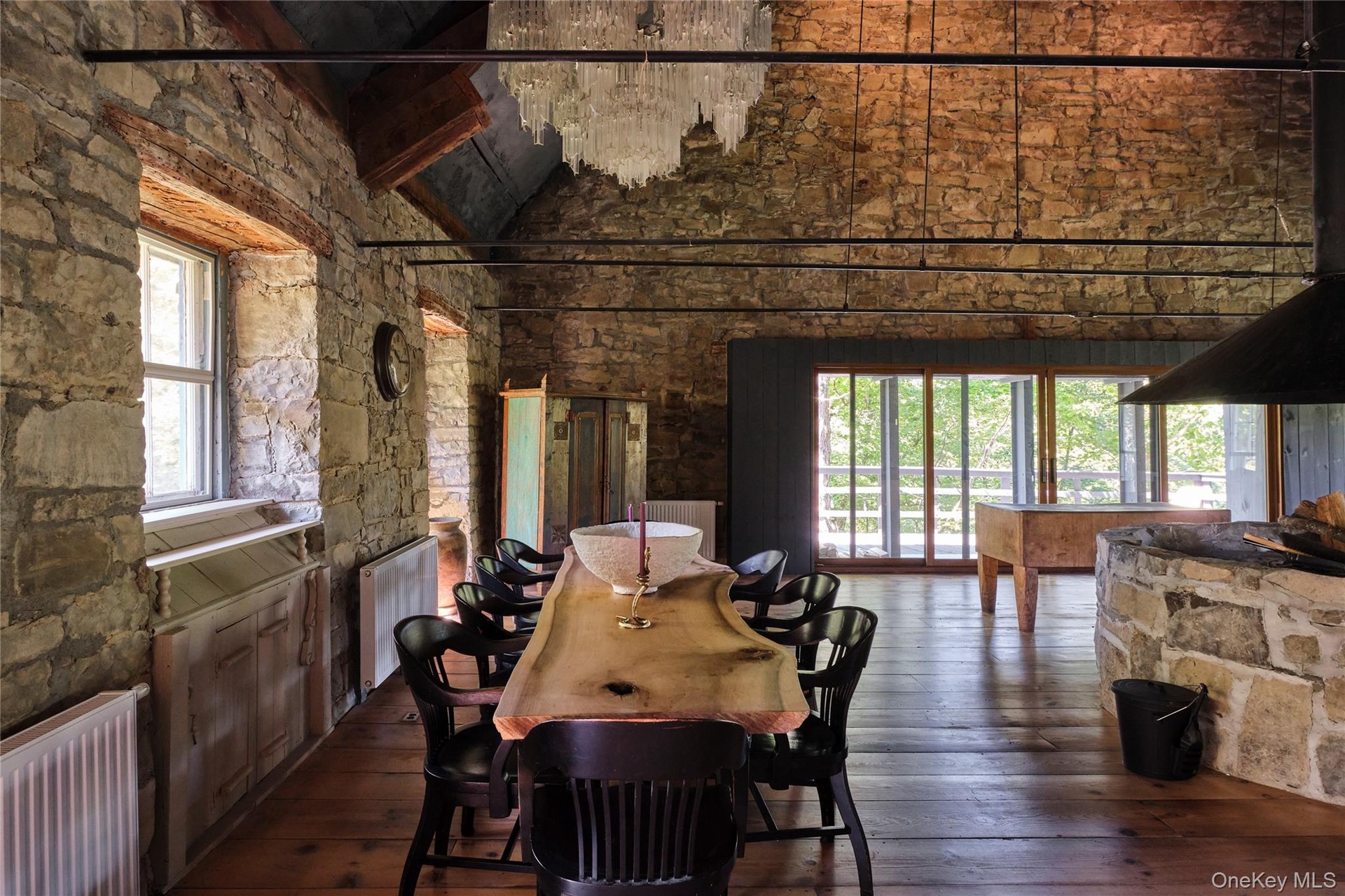 Dining space featuring dark wood-type flooring, radiator heating unit, high vaulted ceiling, and beamed ceiling