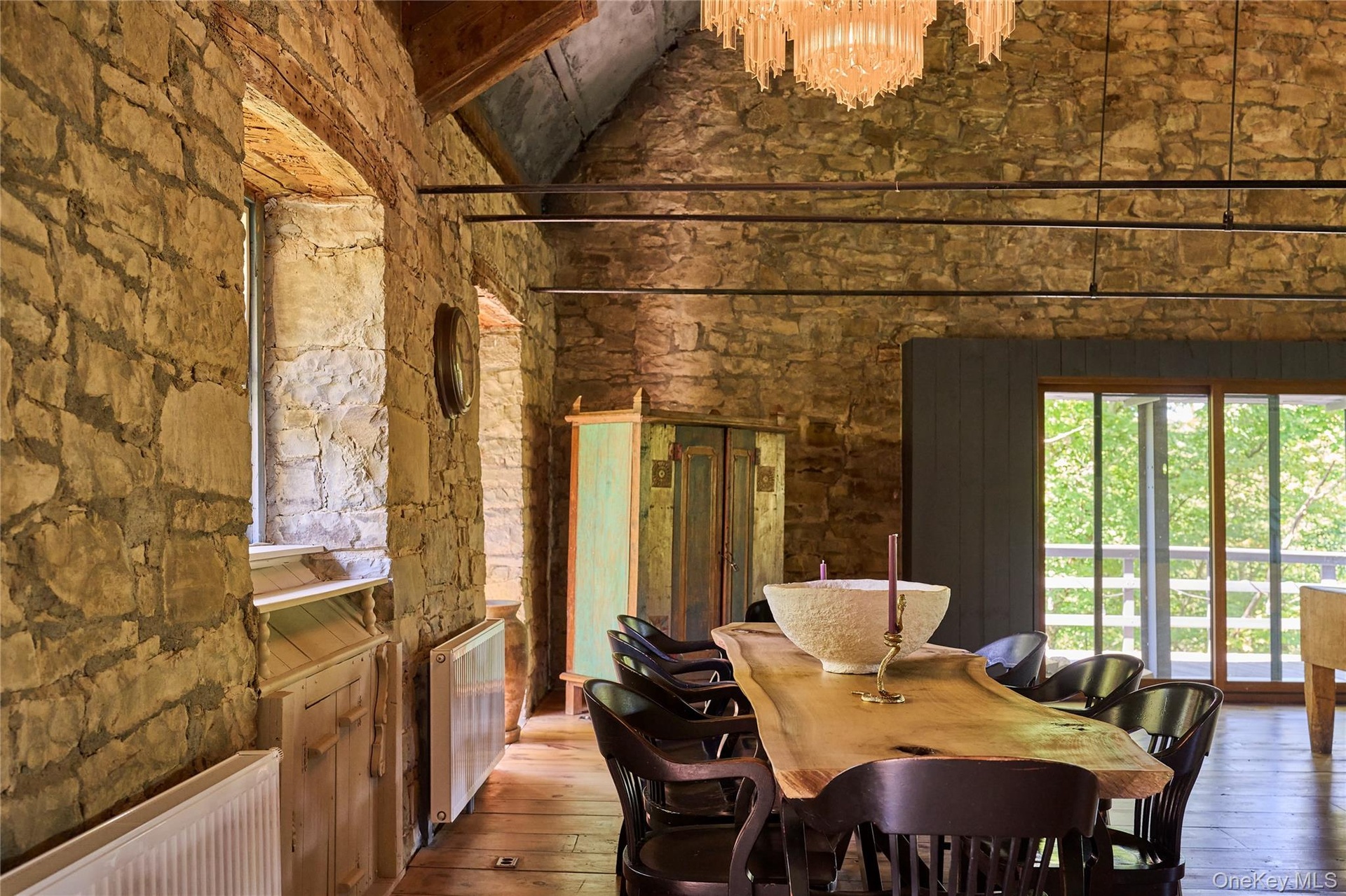 Dining space featuring radiator, hardwood / wood-style floors, a high ceiling, and a chandelier