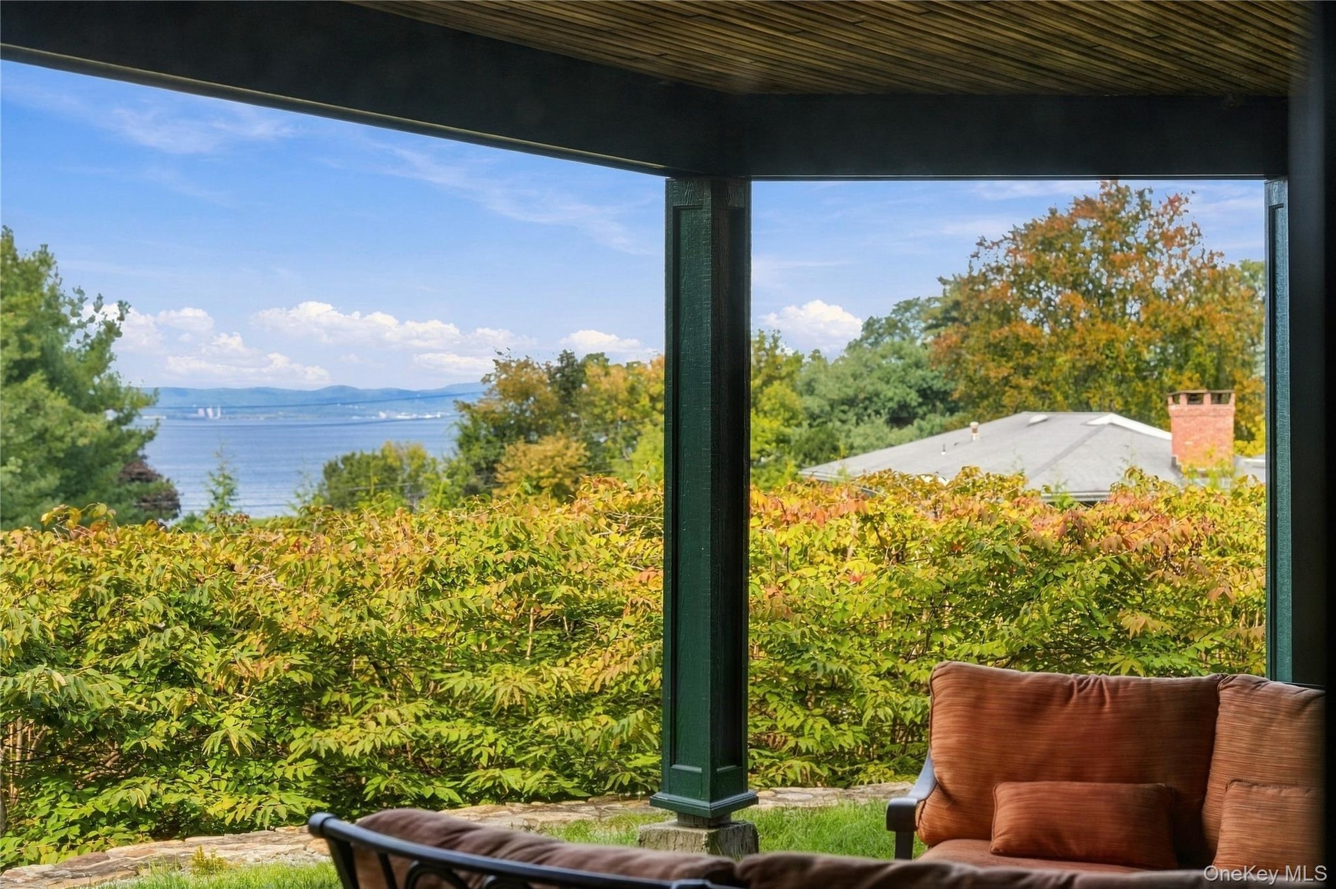 A beautifully designed covered outdoor lounge offering stunning Hudson River views, comfortable seating, and a peaceful setting to enjoy the surroundi