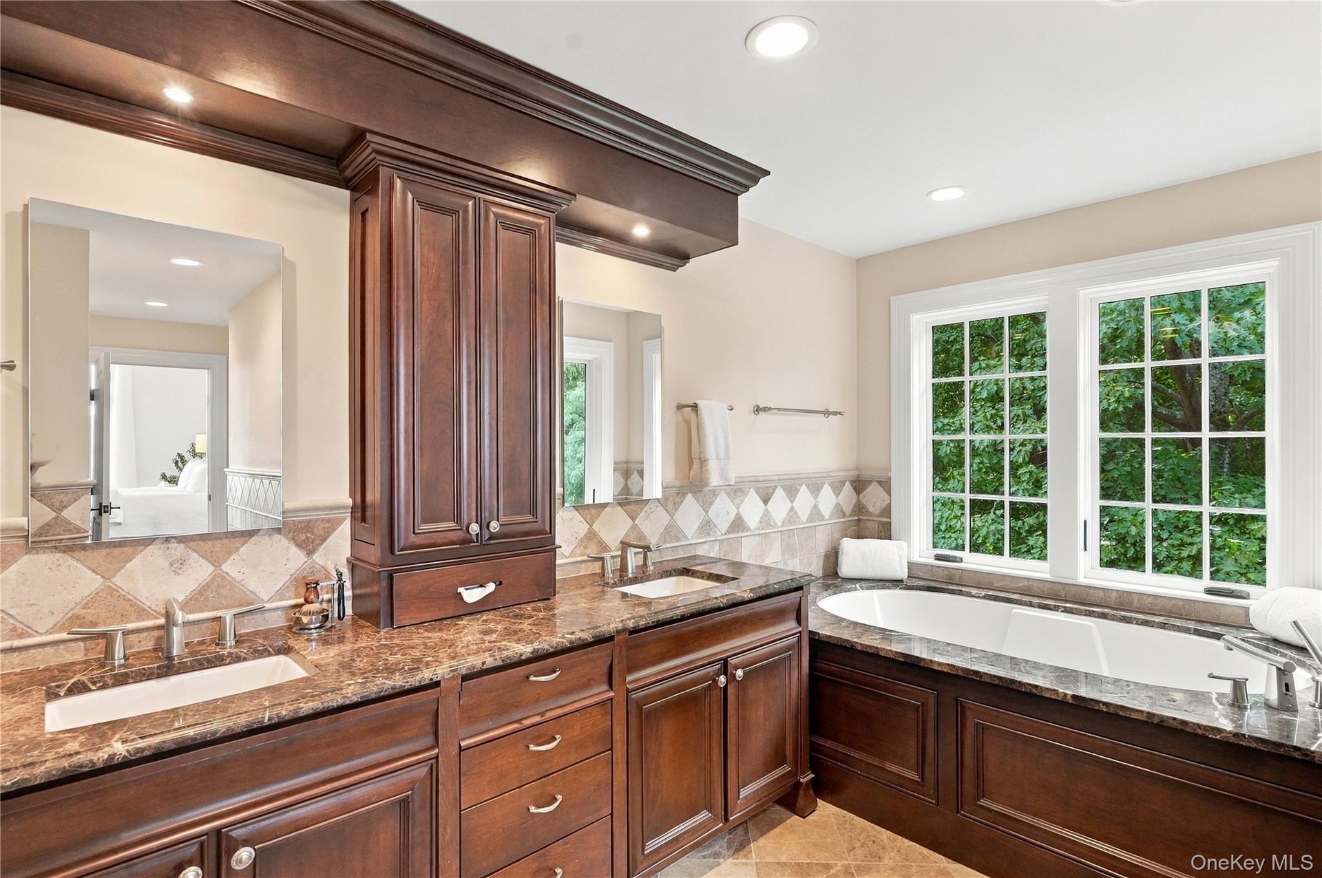 A beautifully appointed primary bathroom featuring custom cabinetry, elegant finishes, and thoughtful details, creating a luxurious and relaxing retre