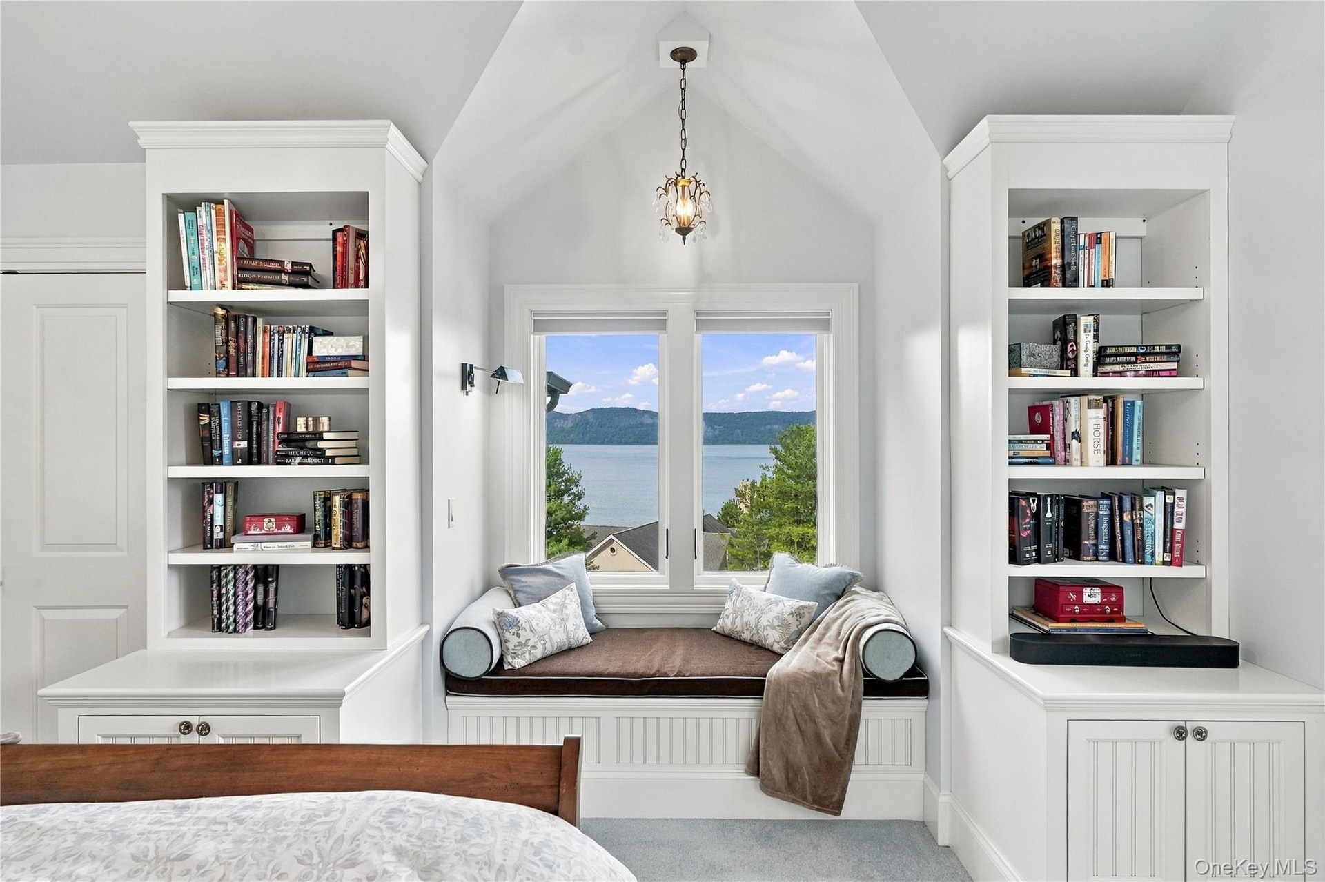 A charming custom window seat framed by built-in bookshelves, offering breathtaking Hudson River views and a peaceful retreat within the bedroom.