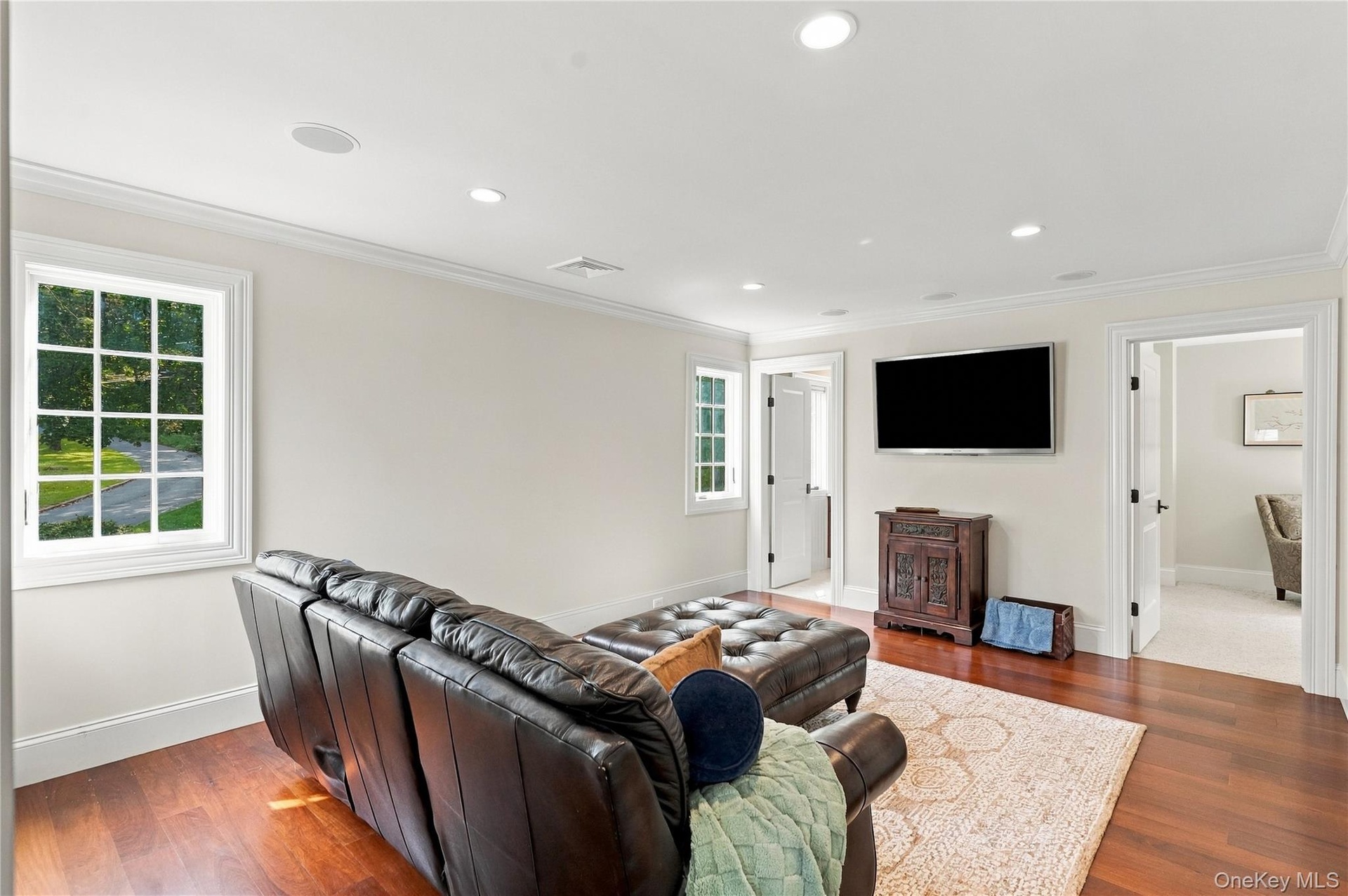 A spacious and inviting sitting room featuring abundant natural light, elegant finishes, and a comfortable setting for relaxation and entertainment.