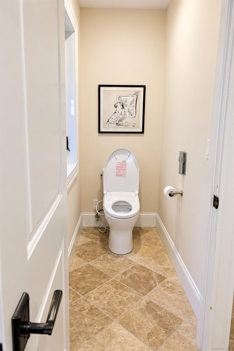 A modern bidet located in a private, enclosed space within the primary bathroom, offering added comfort and privacy.