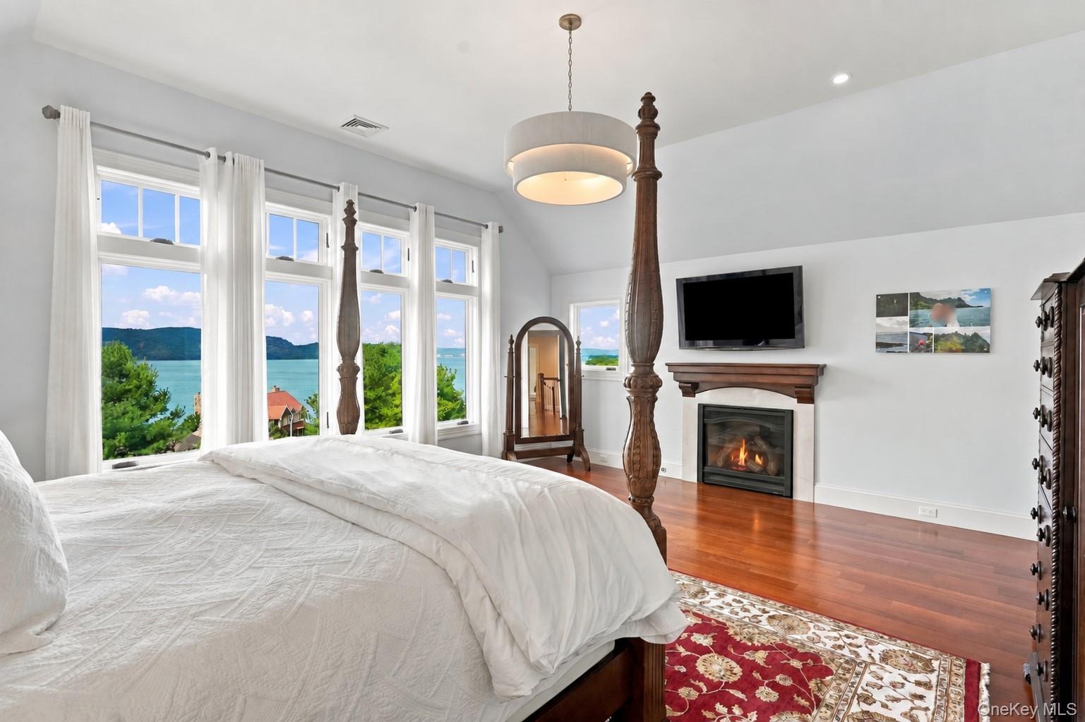 A luxurious primary suite featuring breathtaking Hudson River views, a beautiful fireplace, three custom walk-in closets, and an elegant en-suite bath