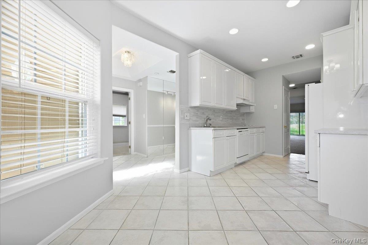 White cabinetry, Kitchen, tile flooring, recessed lighting, and a backsplash