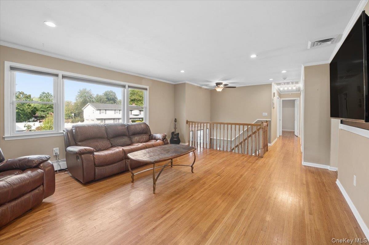 Formal living room with hardwood floors, recessed lighting, picture window and pellet stove.