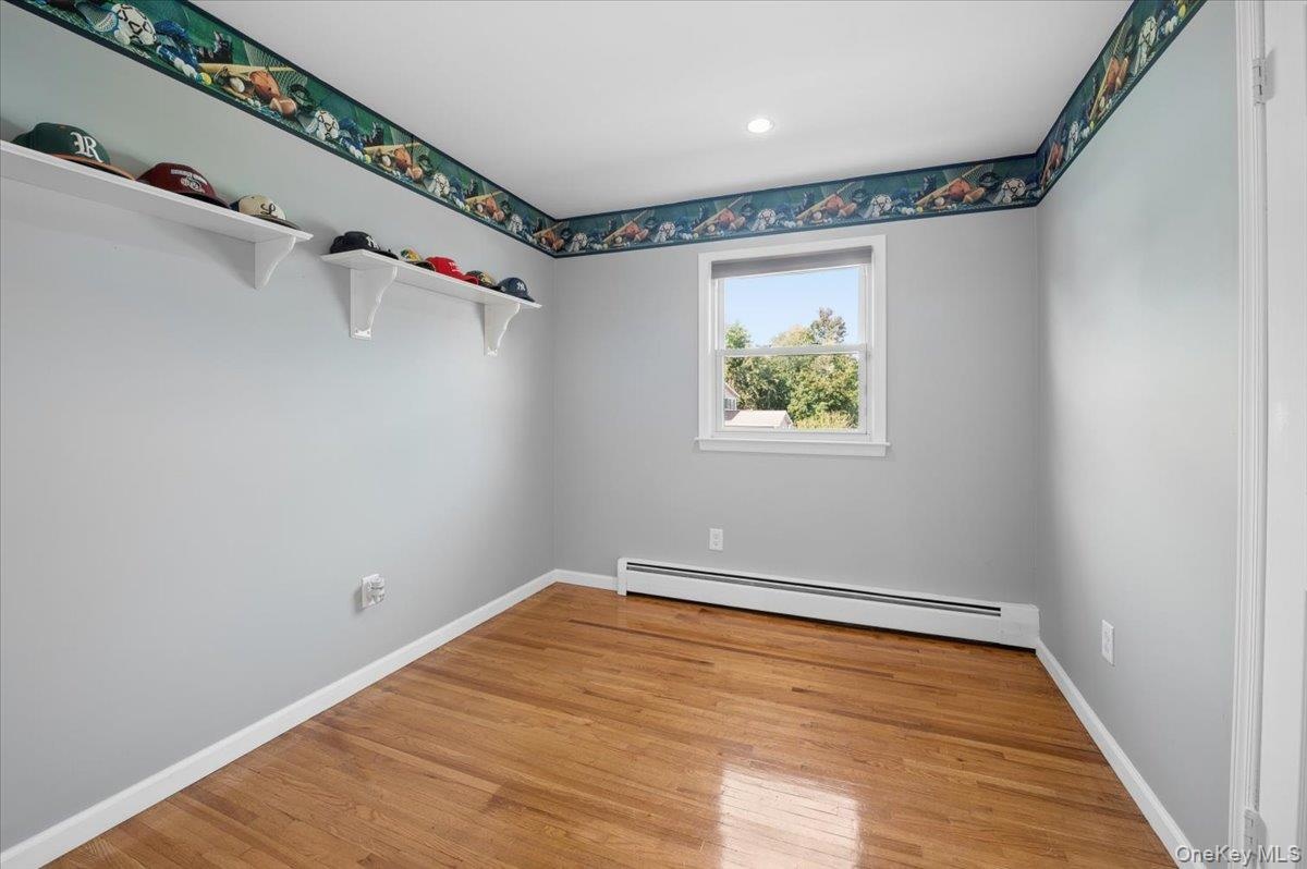 Third bedroom with hardwood floors and recessed lighting.