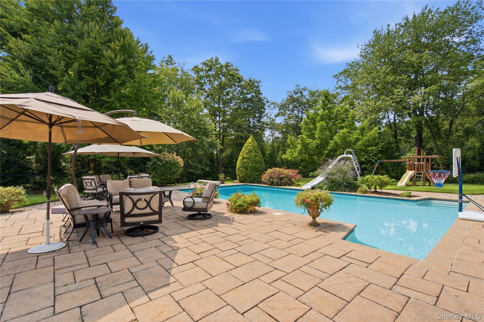 Expansive paver patio surrounding a rectangular swimming pool