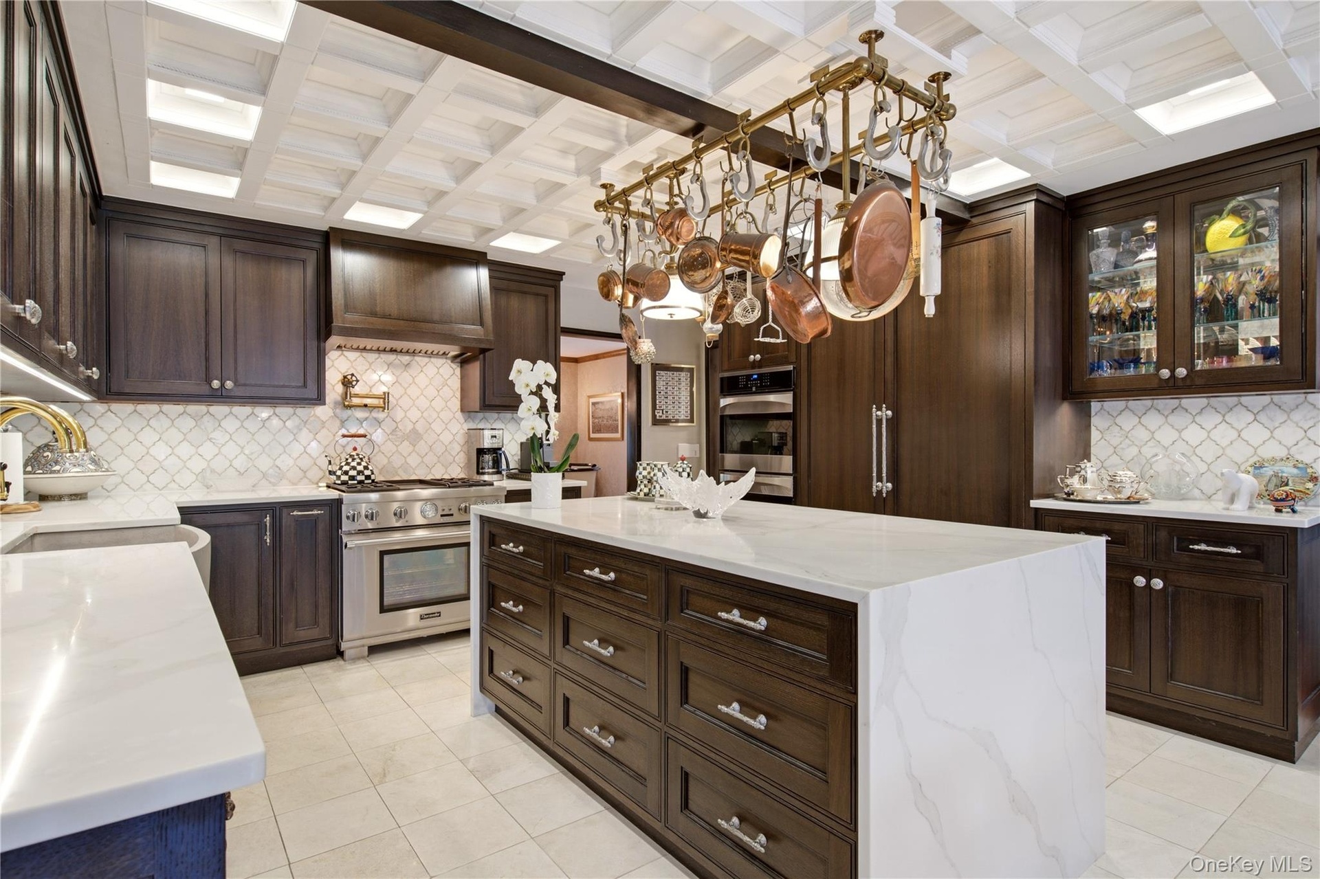 Kitchen featuring a coffered ceiling, black oak  cabinetry, quartz countertops, a large center island, and stainless steel appliances